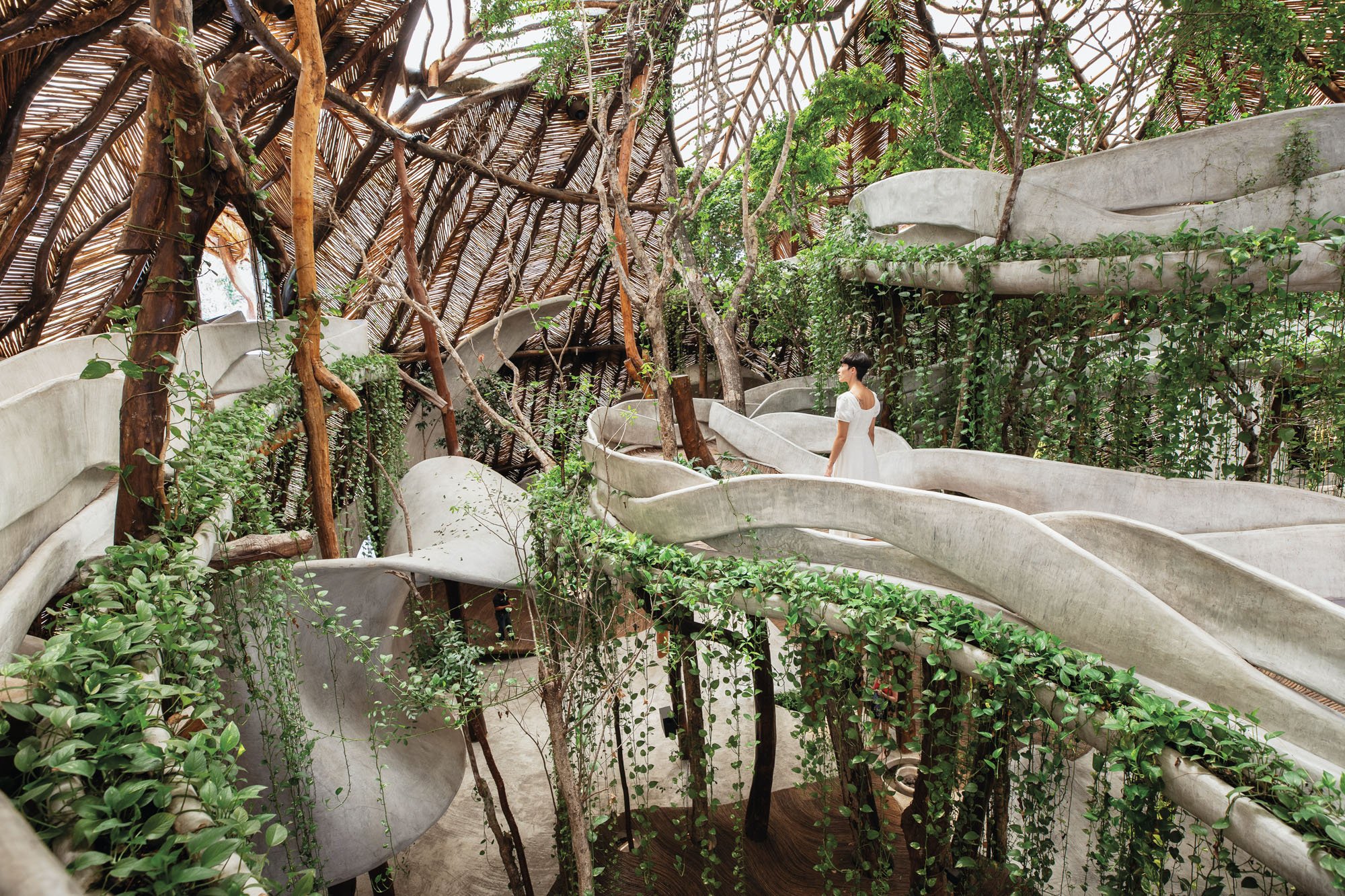 Image of a woman walking across a bridge in a building designed to look like the jungle