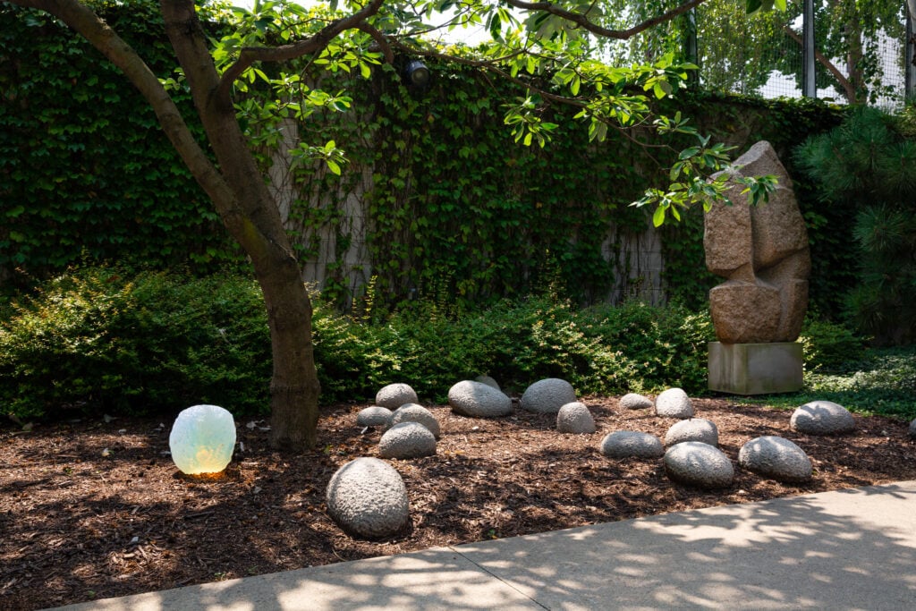 Objects of common interest designs placed near Isamu Noguchi sculptures in the Noguchi Museum Garden. 