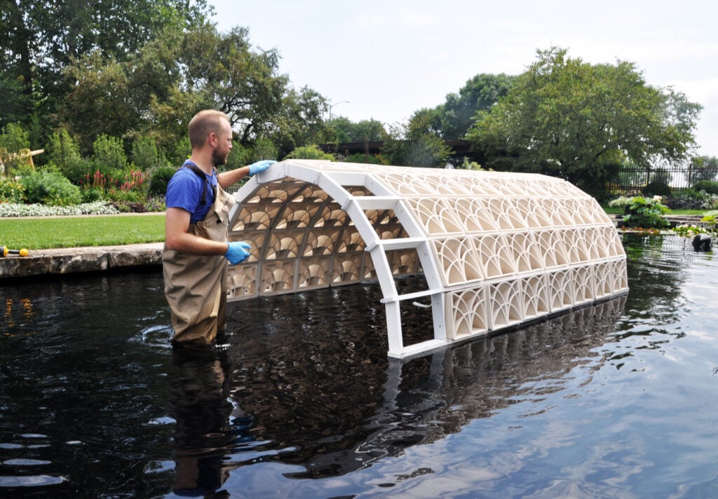 Brian peters inside a reflection pool installing his prairie cord project