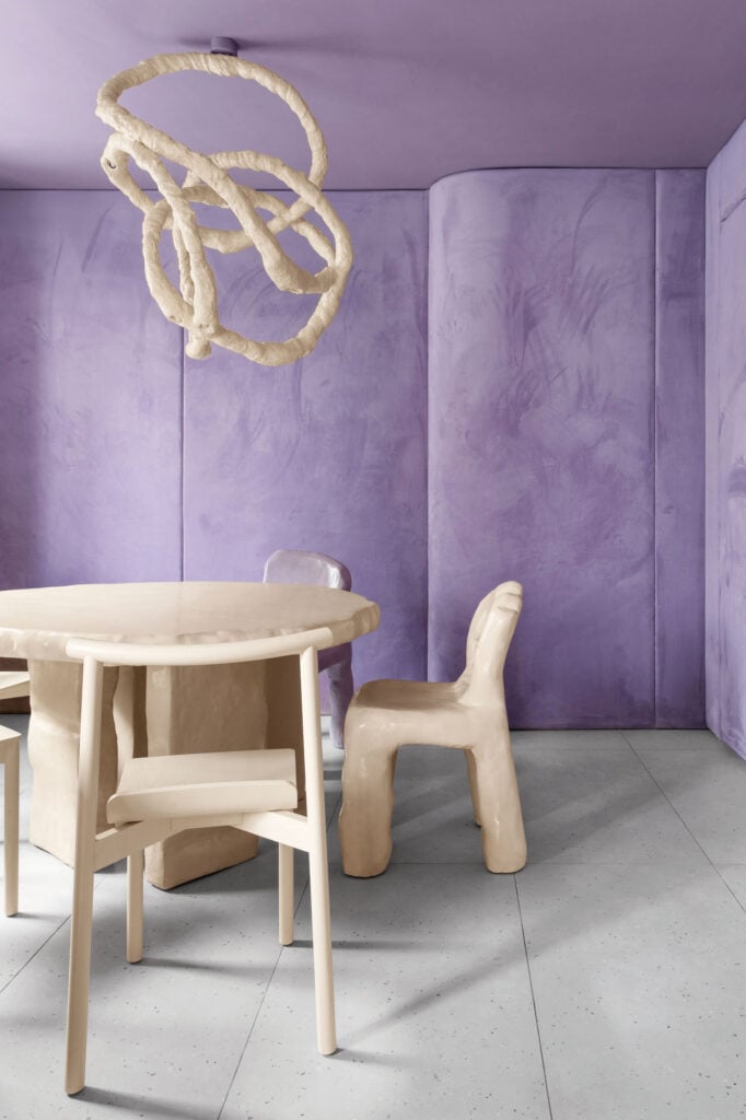 a table and chairs in a purple room