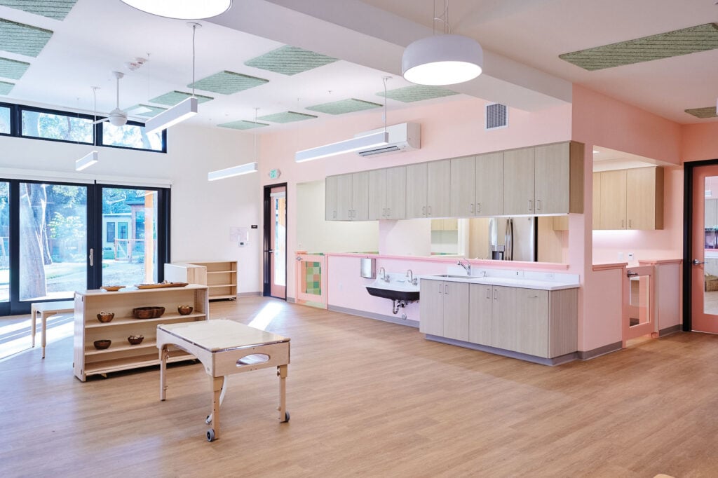 Daycare interior with pink walls ad wooden furniture