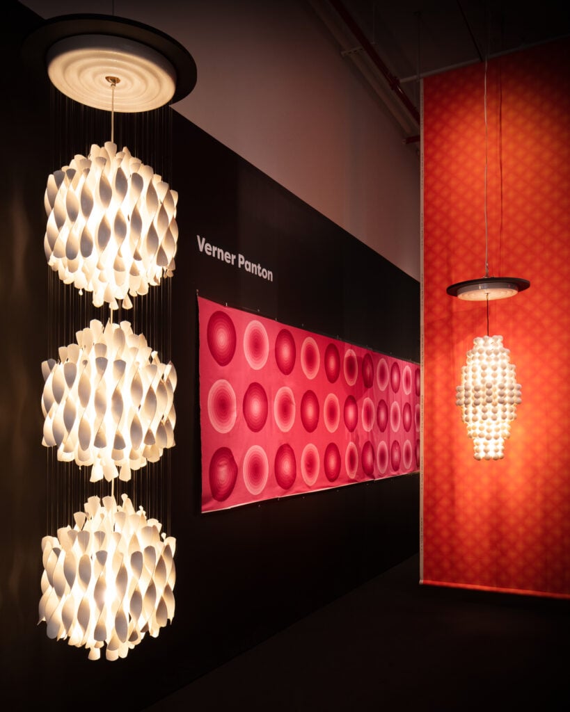 Interior installation of R & Company's Verner Panton Exhibition showing two chandeliers and a wall piece