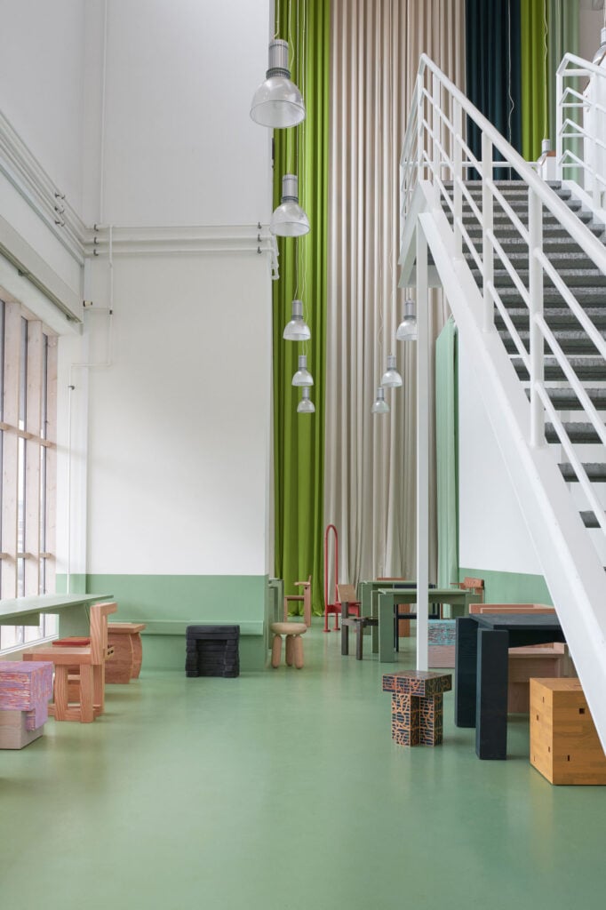 chairs arranged in double height space with white staircase