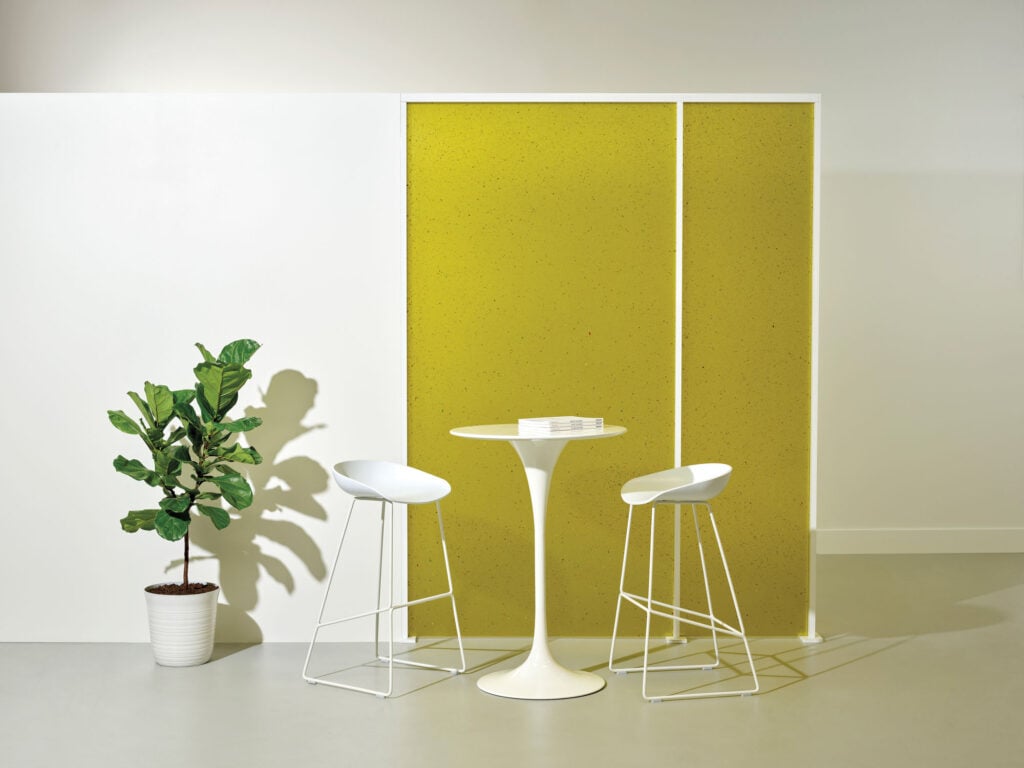 white table and chairs in front of a yellow divider screen