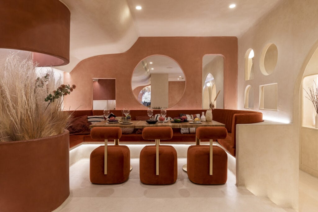 interior of a restaurant with velvet orange seating and cut out windows