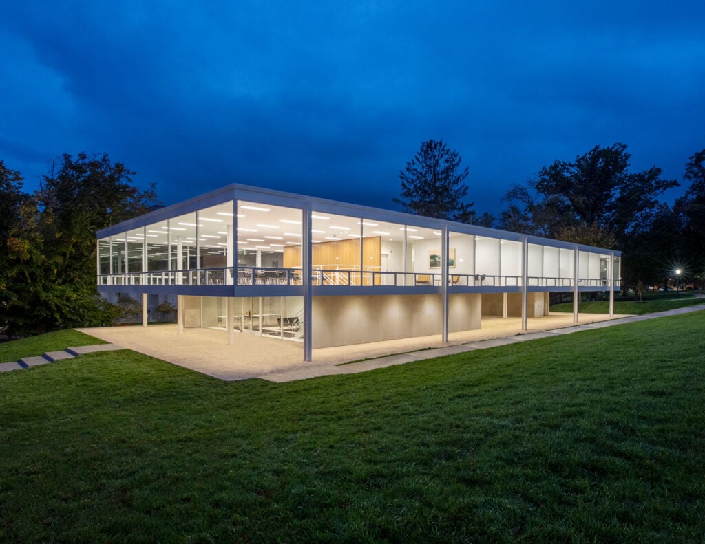 modernist building with glass walls, night.