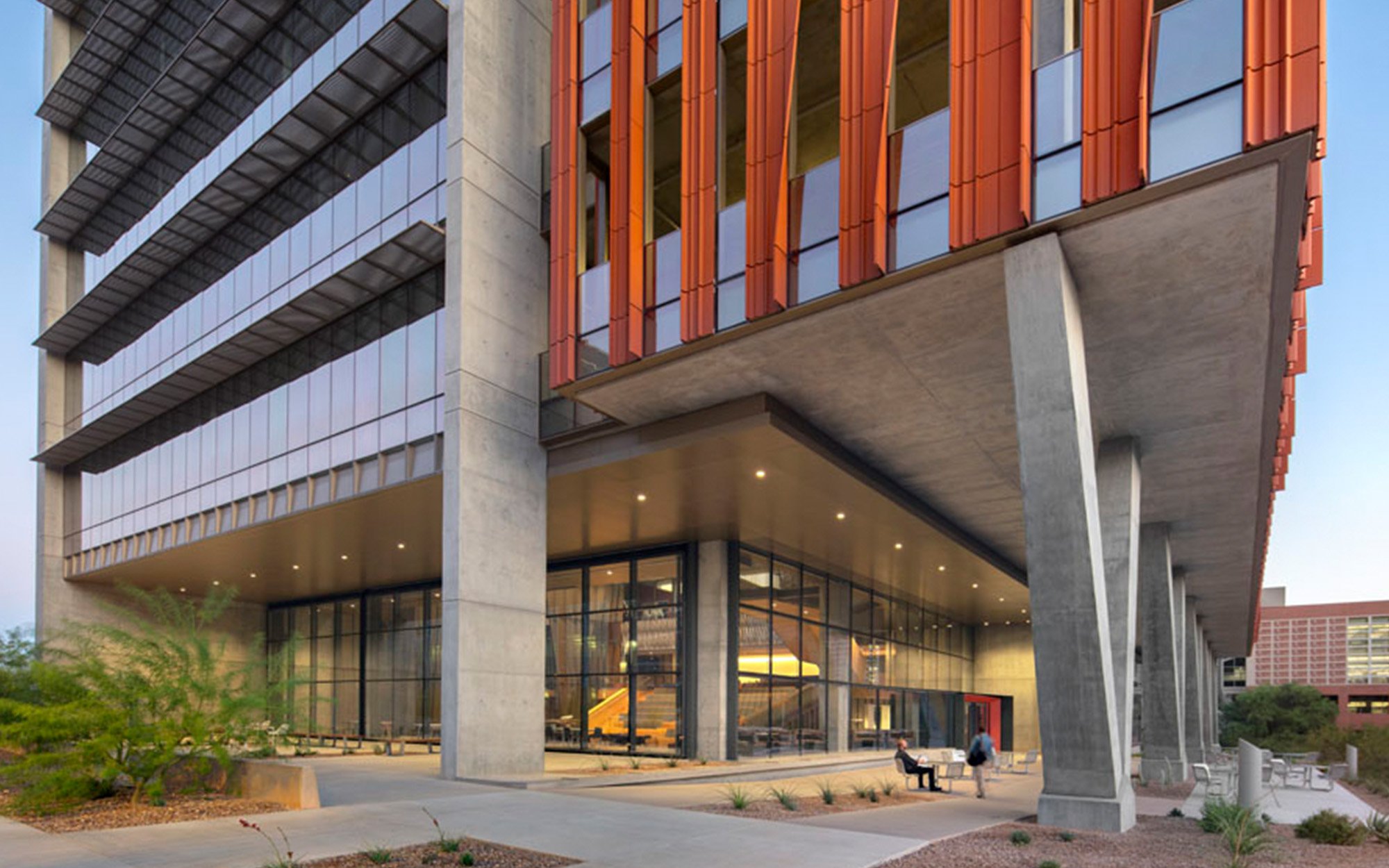 An exterior image of a concrete and glass building entrance 