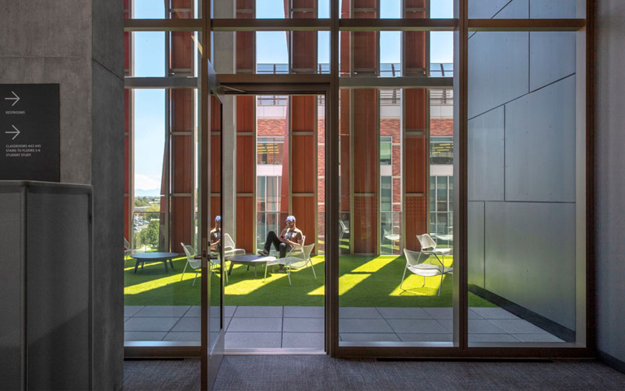 an interior image looking out onto a terrace of an educational building