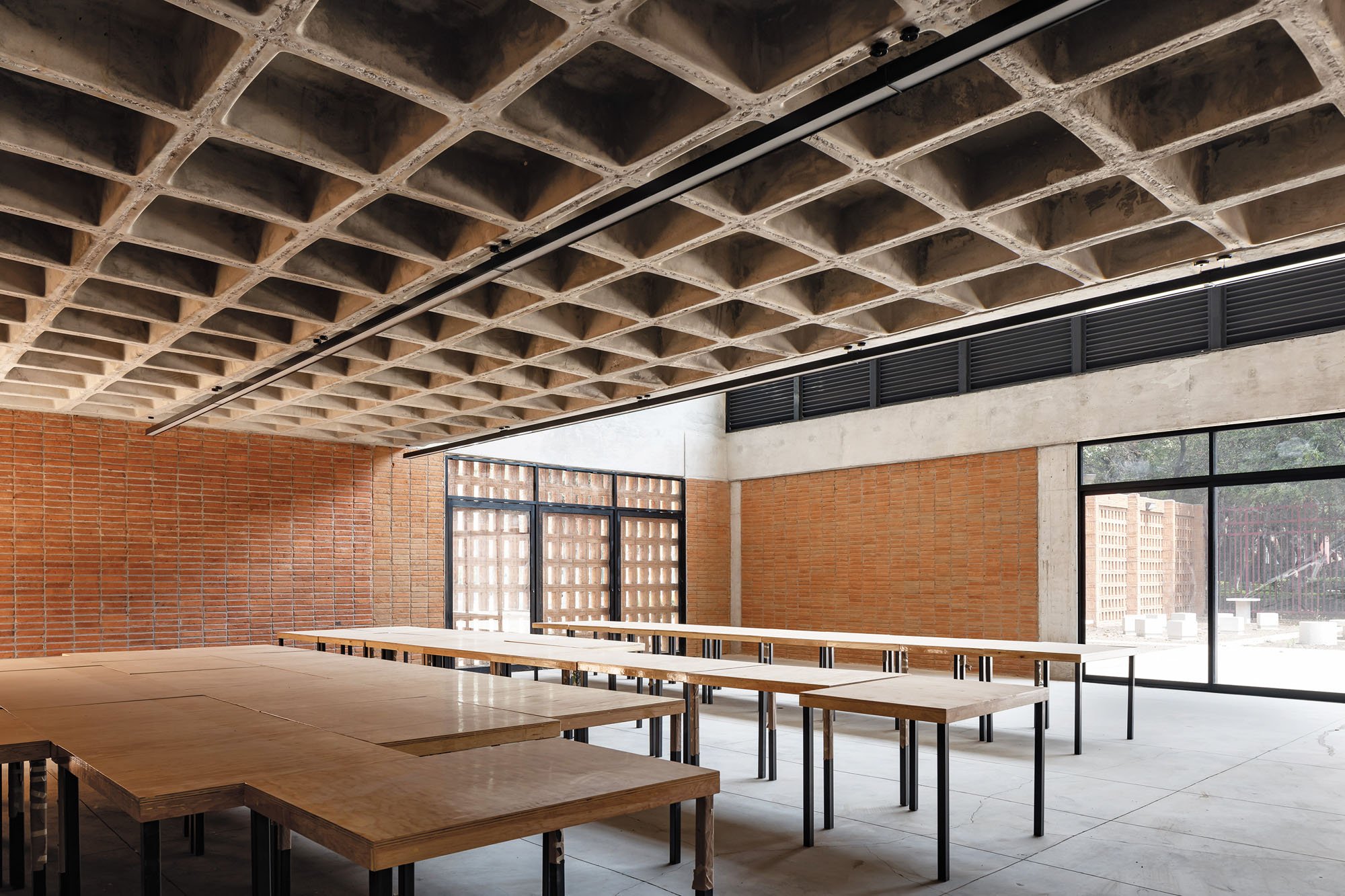 a photograph of a coffered cement ceiling inside brick building, part of the Pilares project in Mexico City