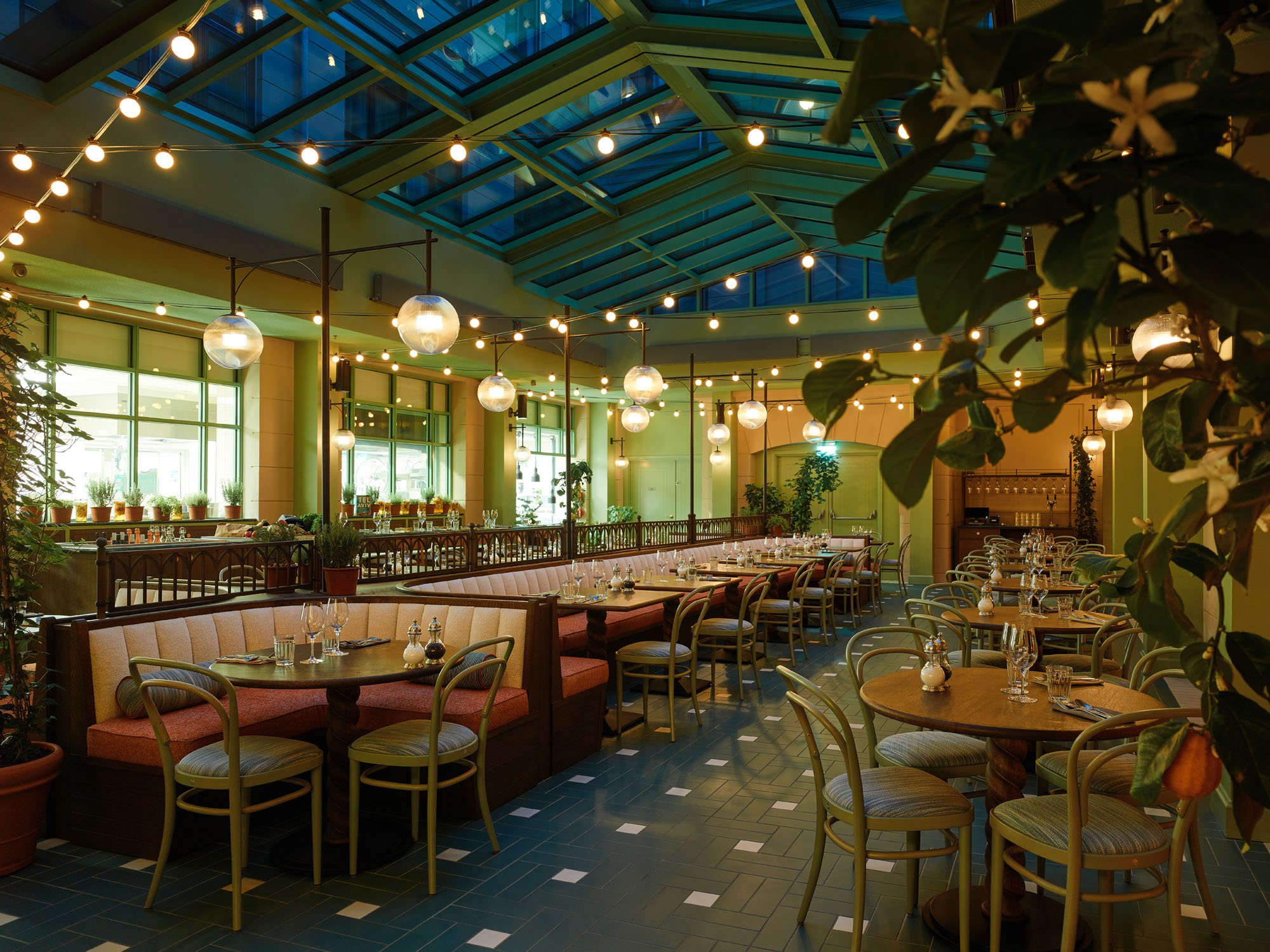 interior of hotel restaurant with string lights and green and white tiled floor