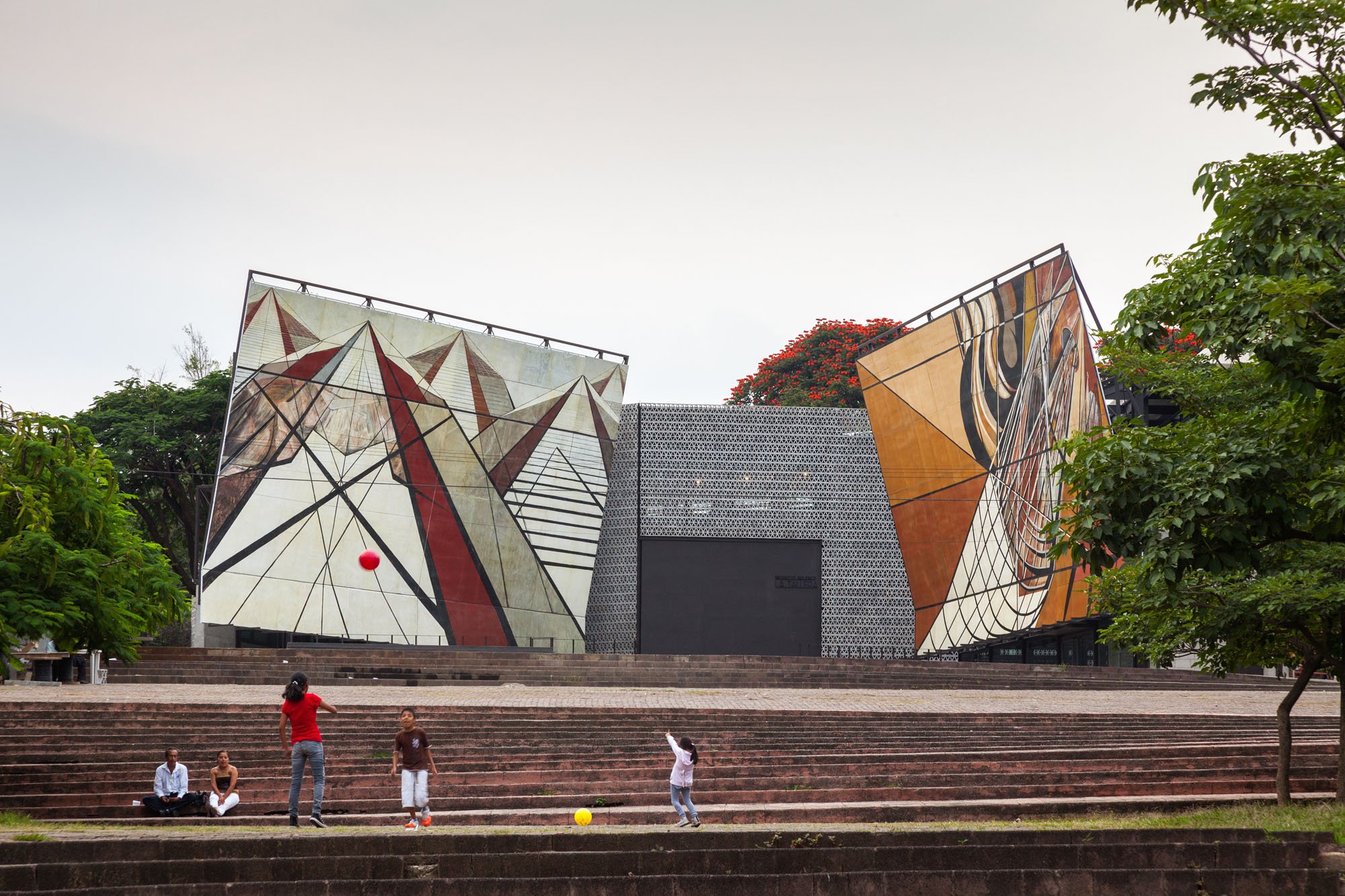 an art museum comprising three volumes, the middle volume is made of cement blocks