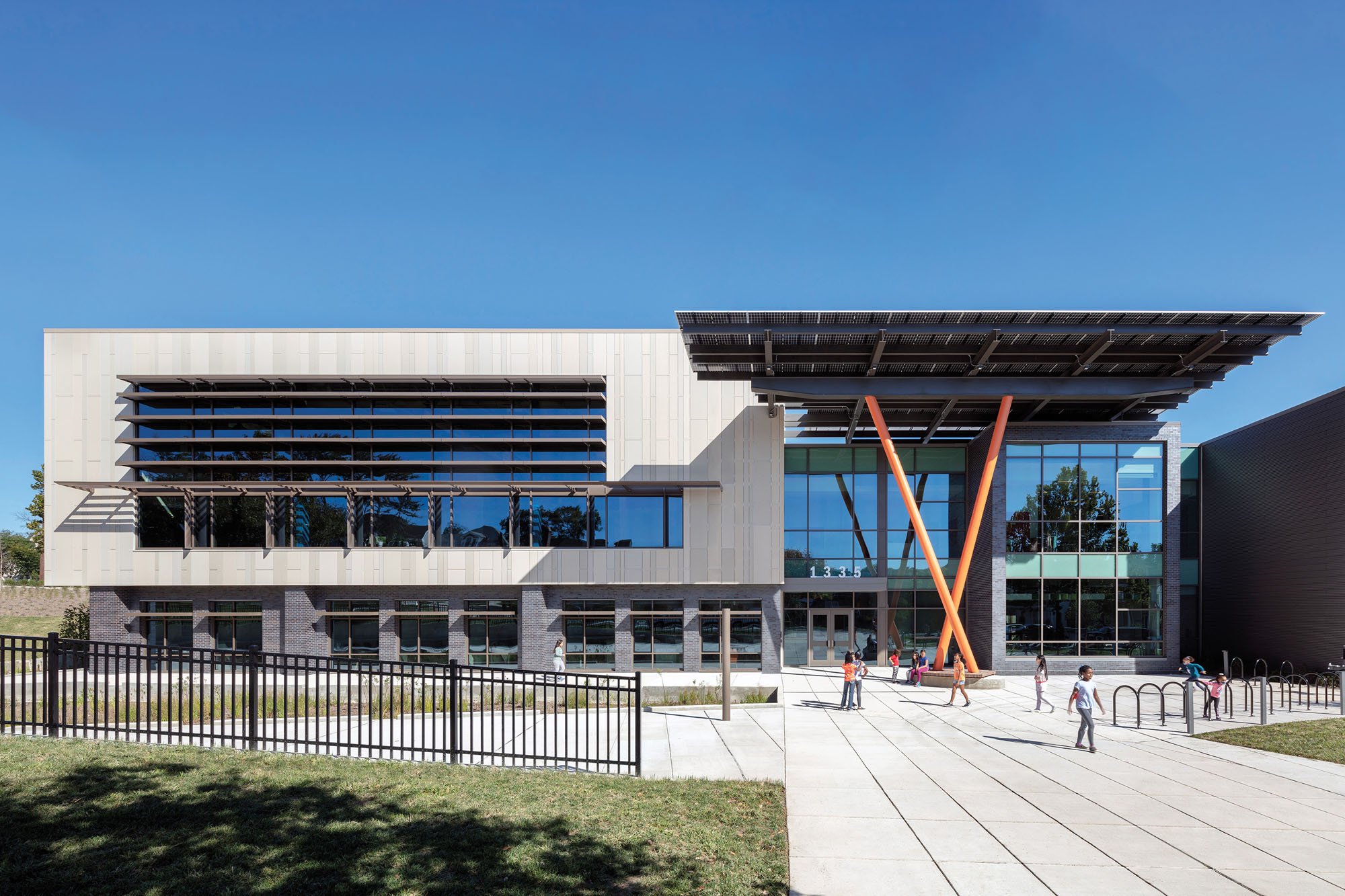 exterior of John lewis elementary, rectangular building with a flat portico and orange columns