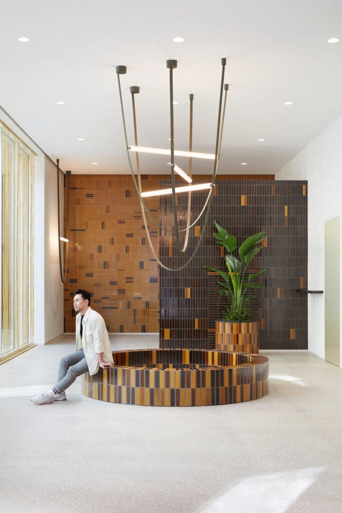 interior with tiled wall and man sittong on circular bench