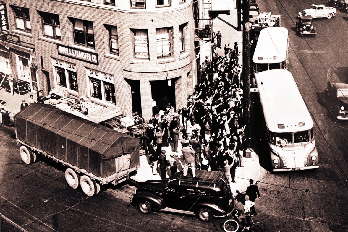 aerial view of people and busses on a street corner. black and white.