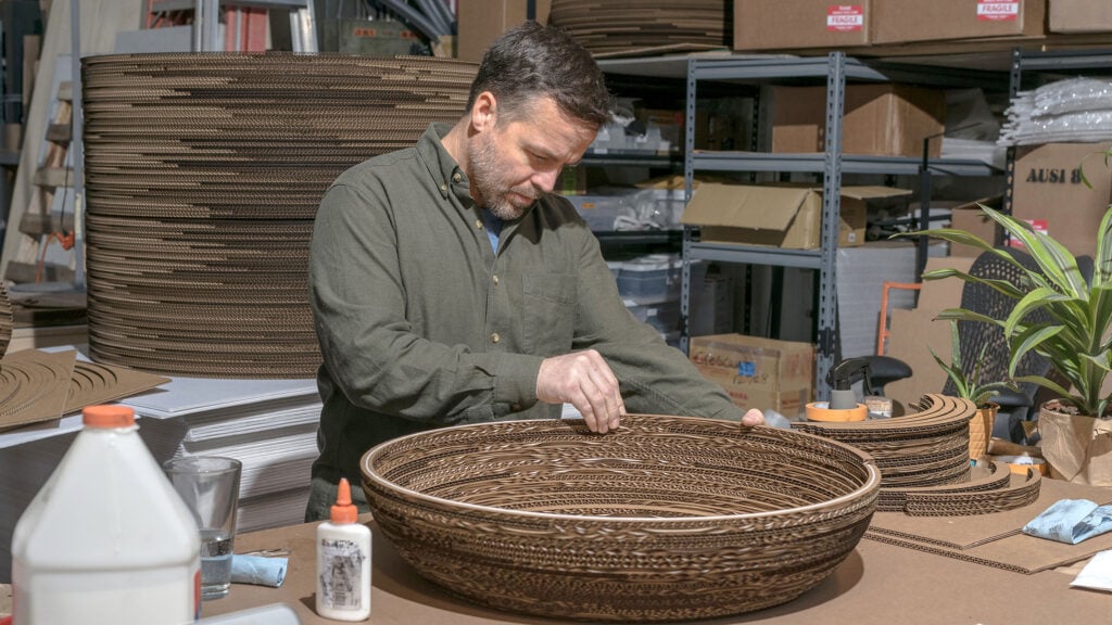 a man building a craft object out of cardboard