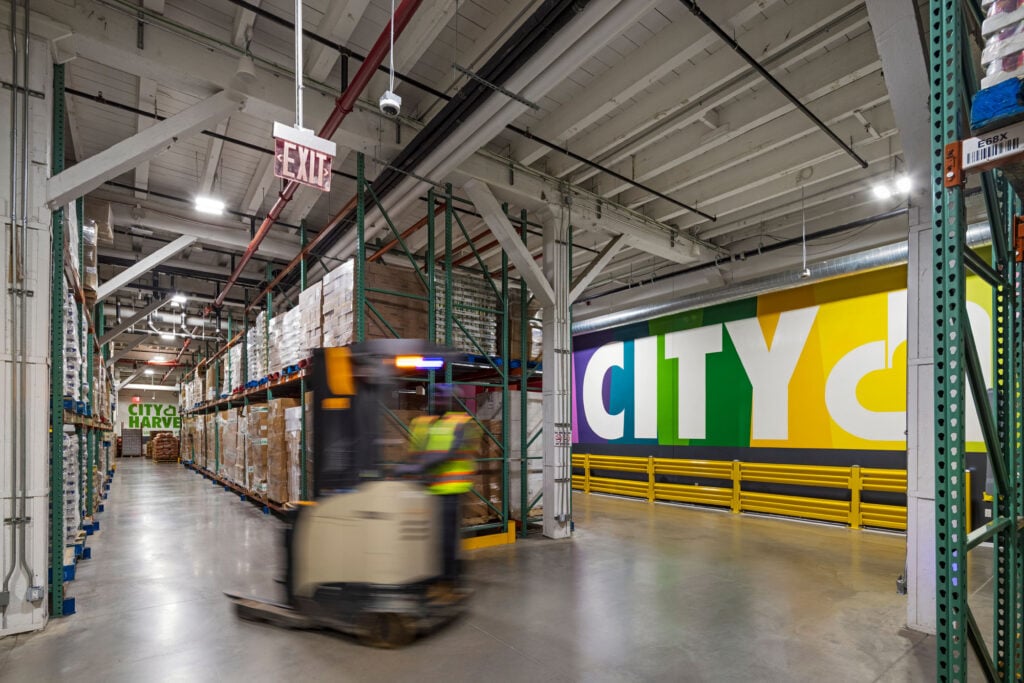 a photograph of a stockroom with a forklift moving through the aisles