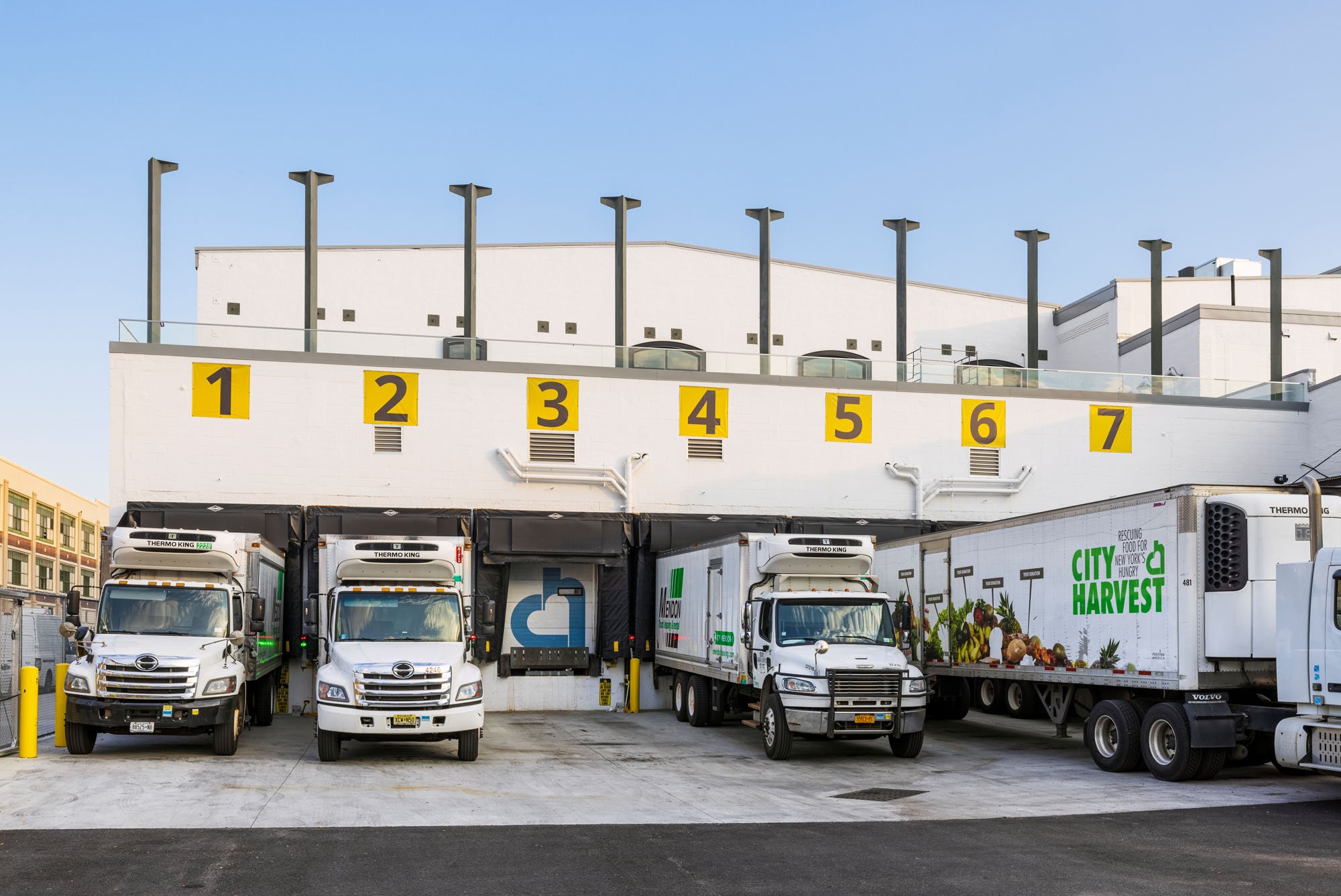 a photograph of trucks pulled up to a row of loading docks