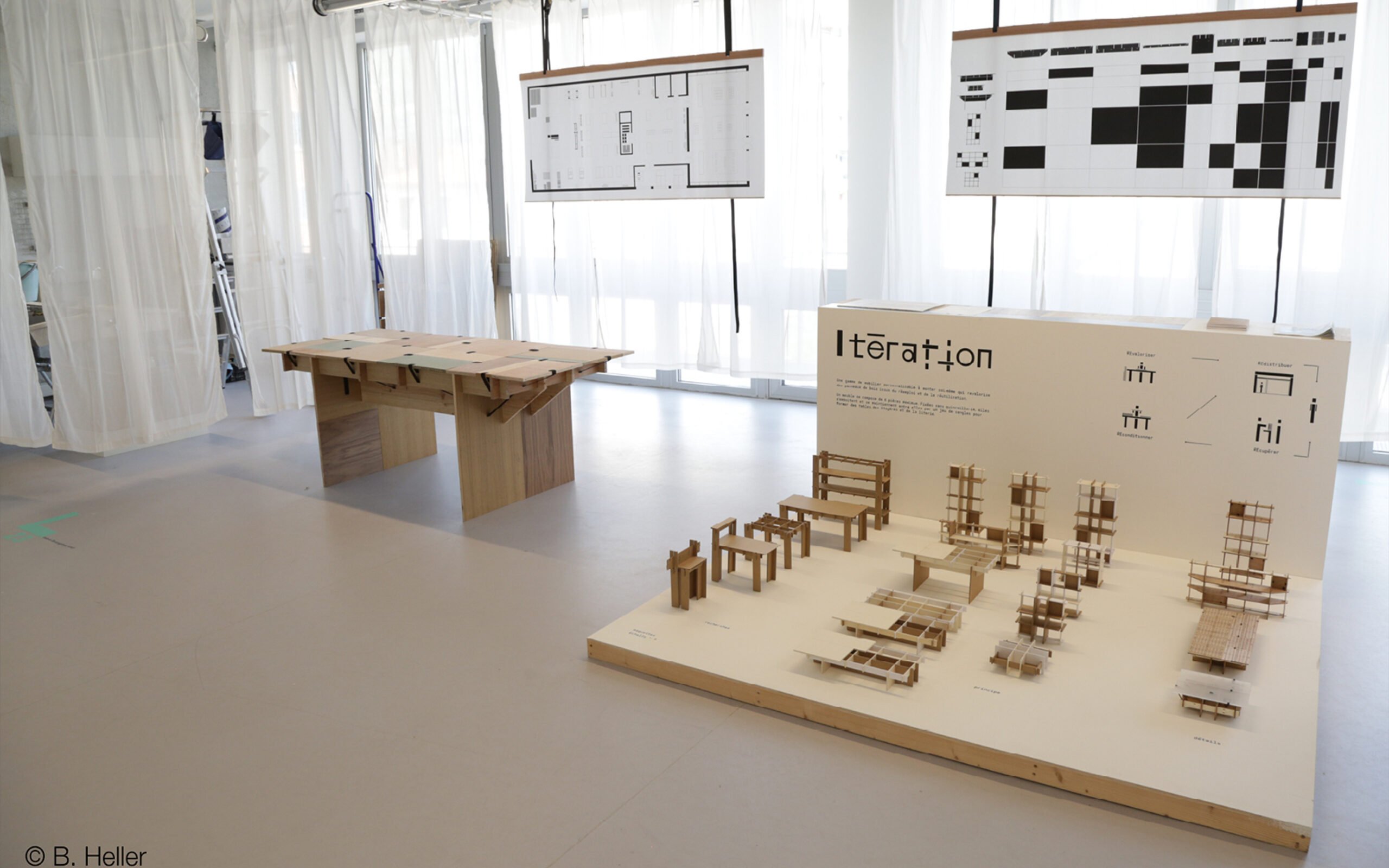 An exhibit showing a modular furniture concept, with a full-size table and miniature models of other pieces