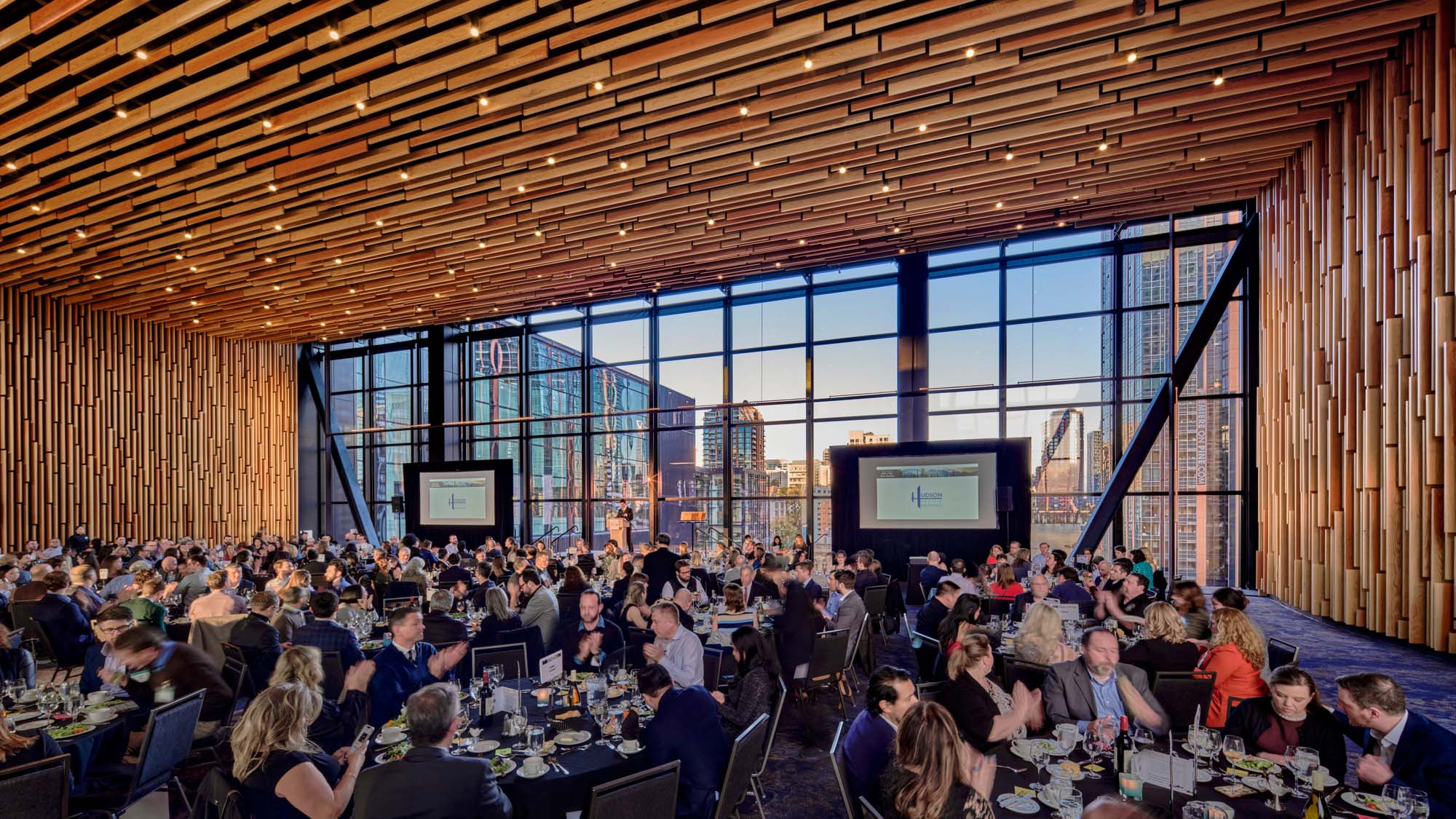 Convention center conference room with round tables and presentation screens