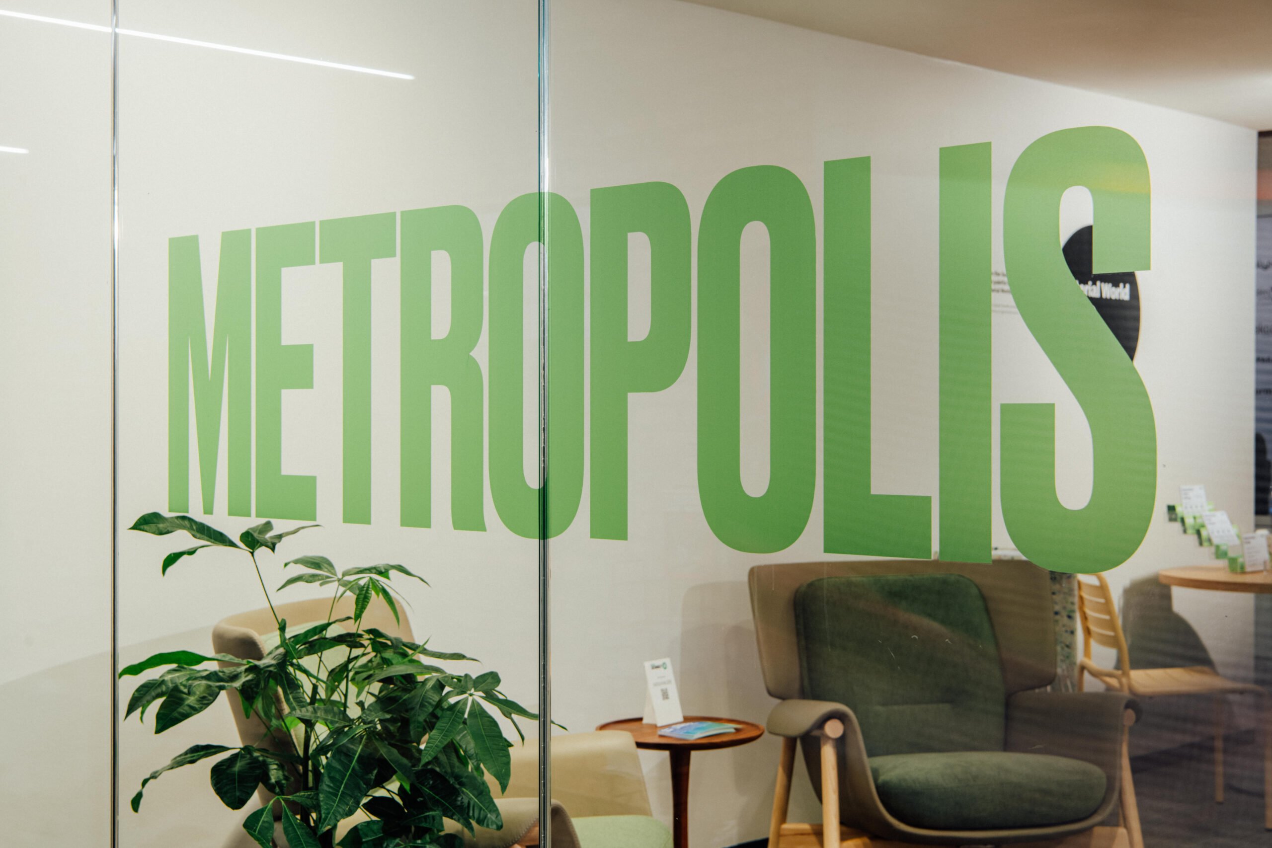 Metropolis Logo in green decal on glass overlooking the Sustainability Lab Leadership Summit at Neocon.