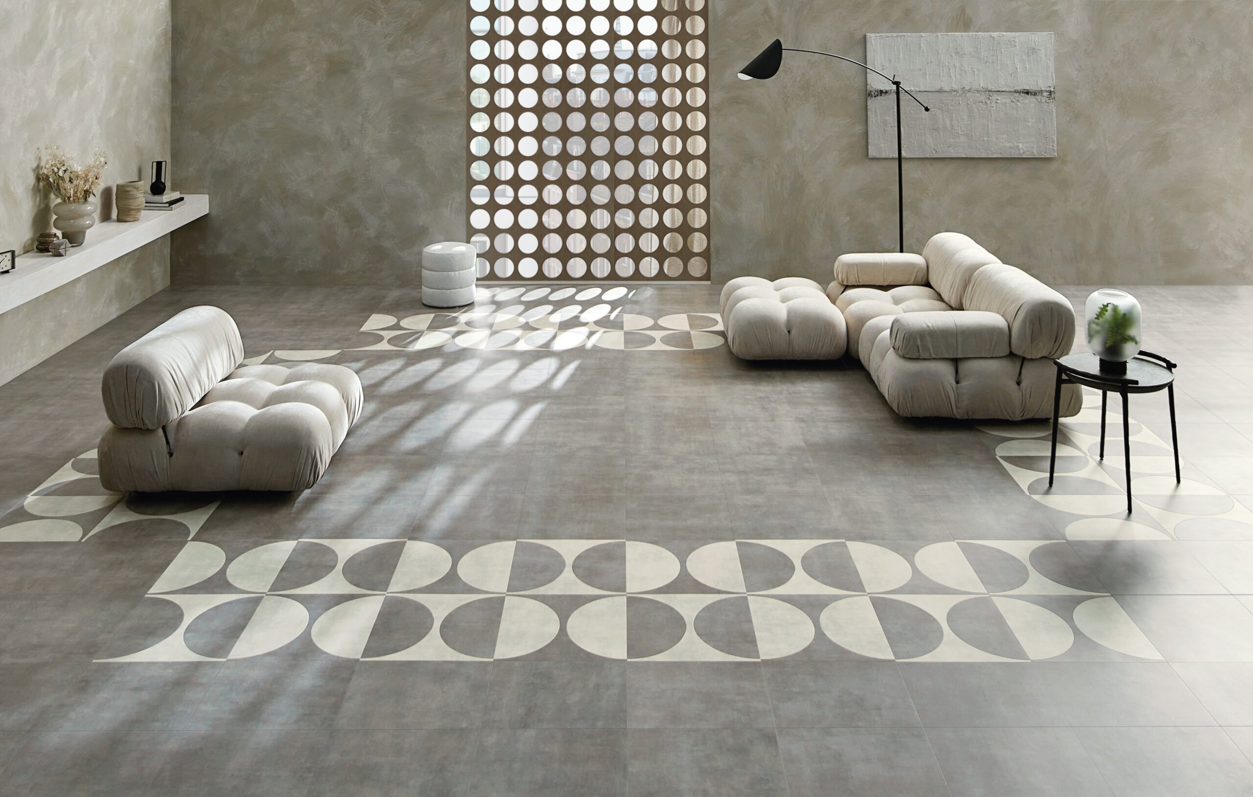 bubble couches placed facing each other on a concrete like grey flooring with a circular border print.