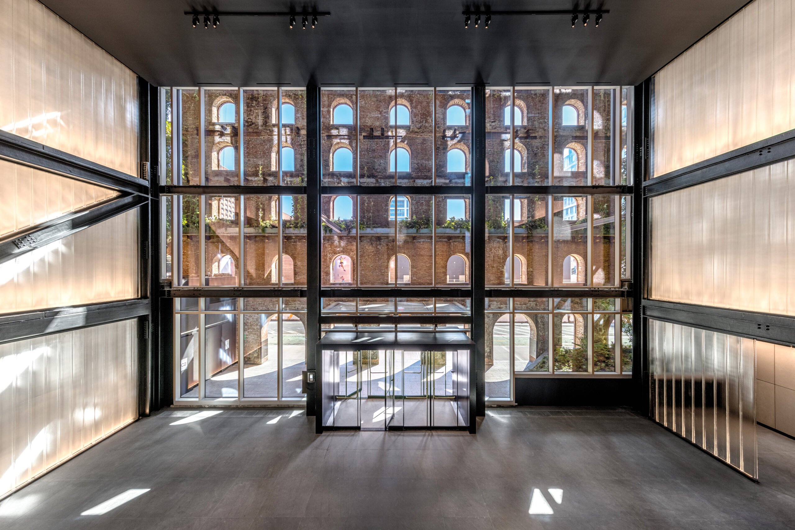 A clear window at the entrance of a building with black metal framing 