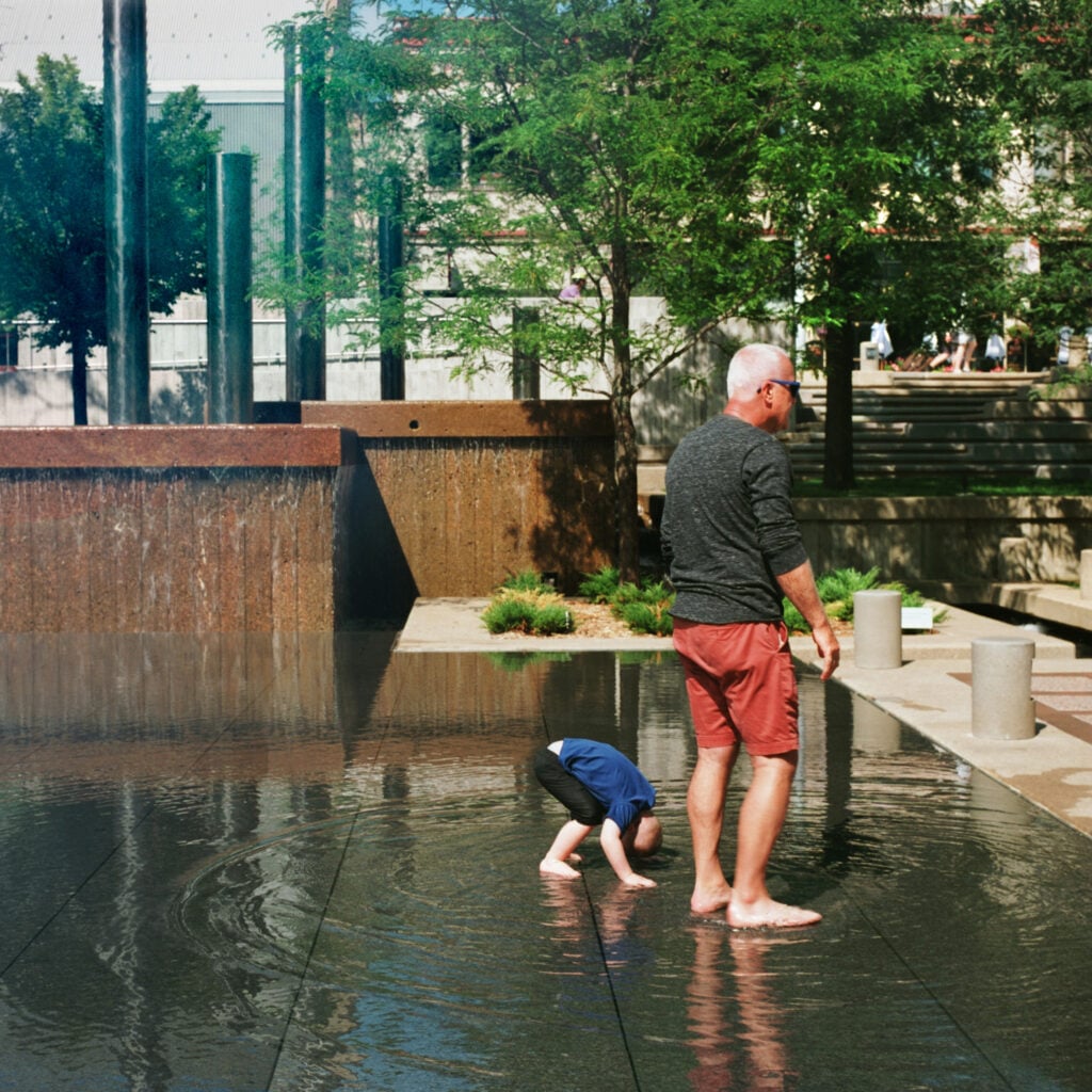 image of a concrete fountain and urban plaza in minneapolis with two people standing in it 