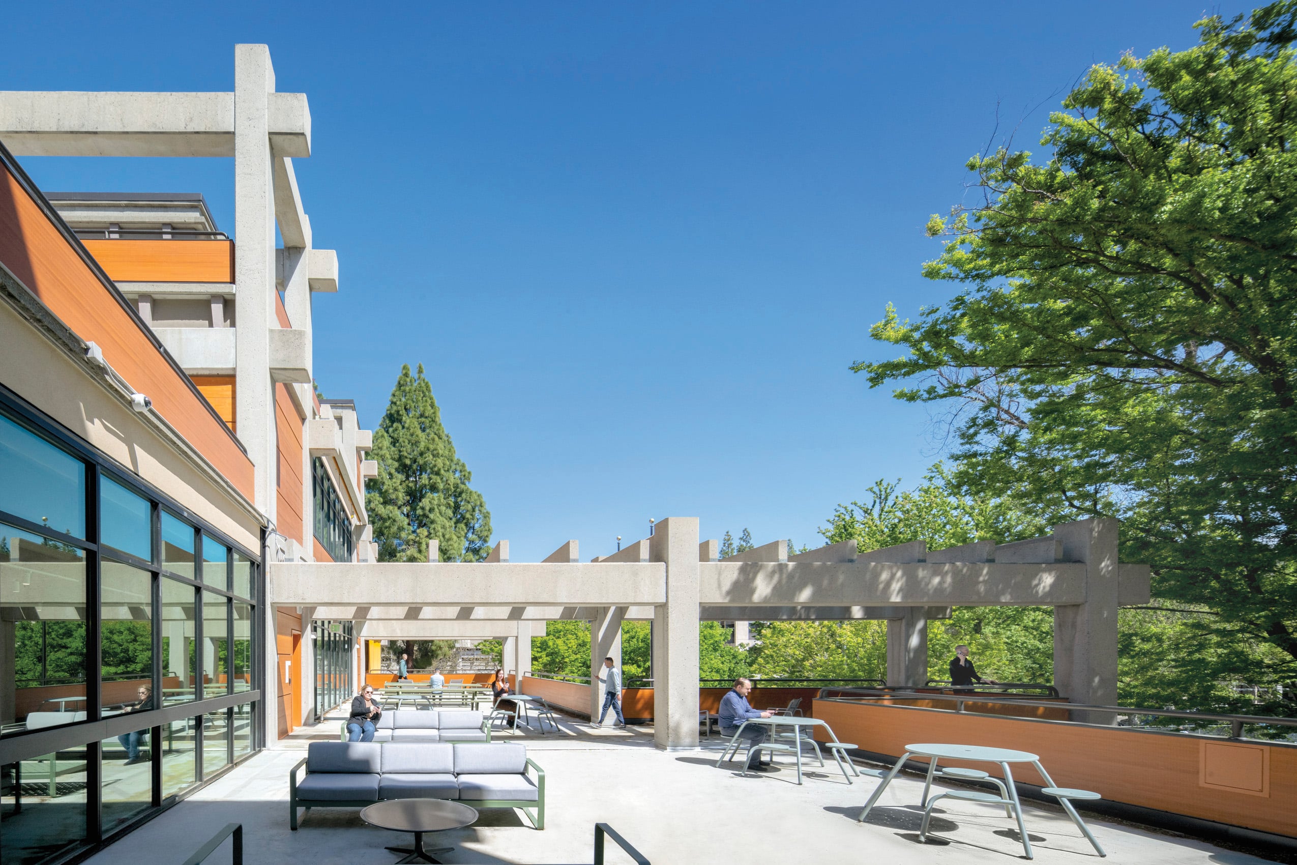 Exterior view of the renovated Gregory Bateson Building in Sacramento, showcasing the exposed post-and-beam concrete structure and custom-milled Douglas fir glulam panels.