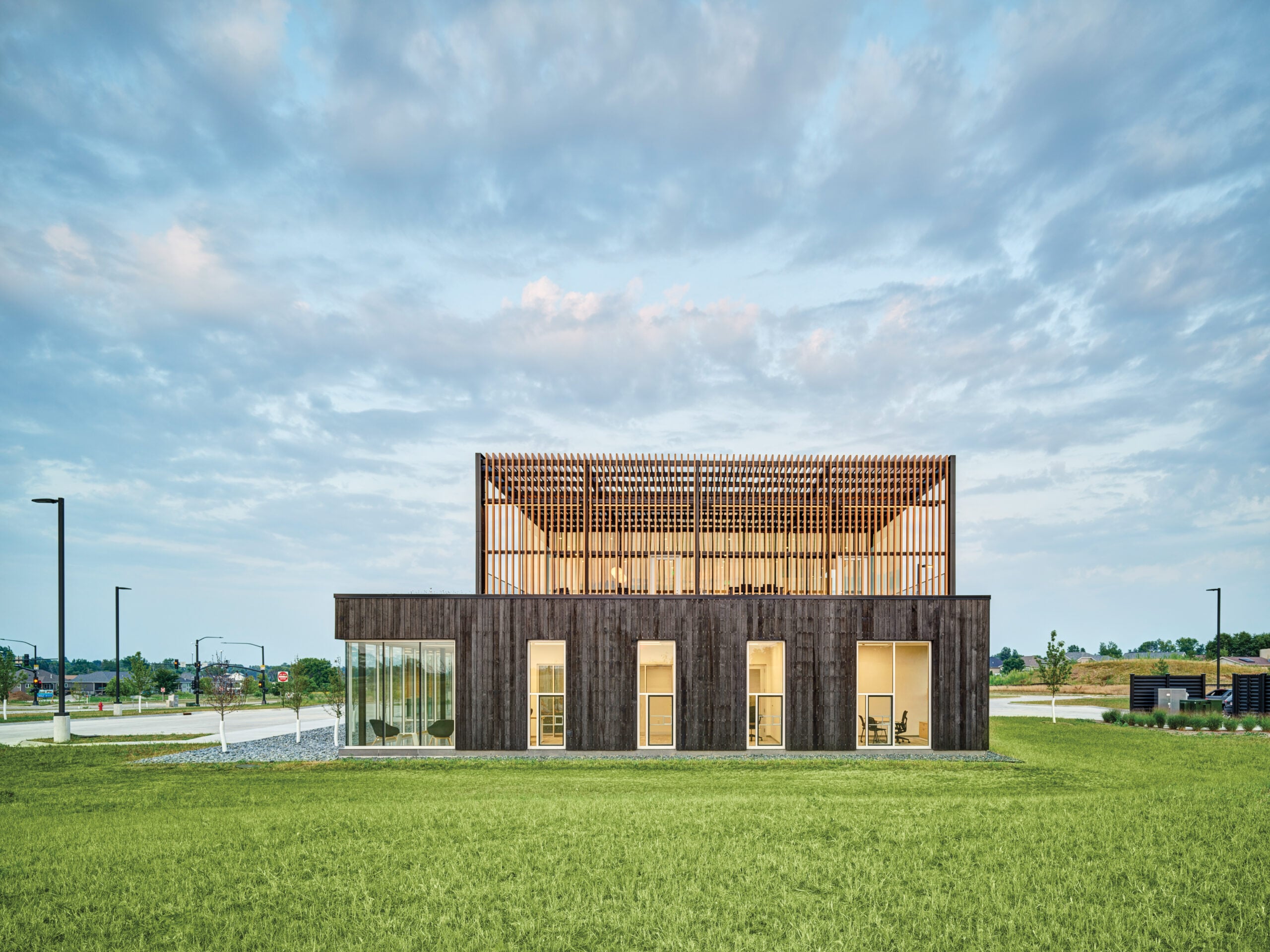Exterior of the Marion Fire Station in Iowa by OPN Architects, featuring dark scorched-wood cladding and large glass windows designed to support firefighter mental health