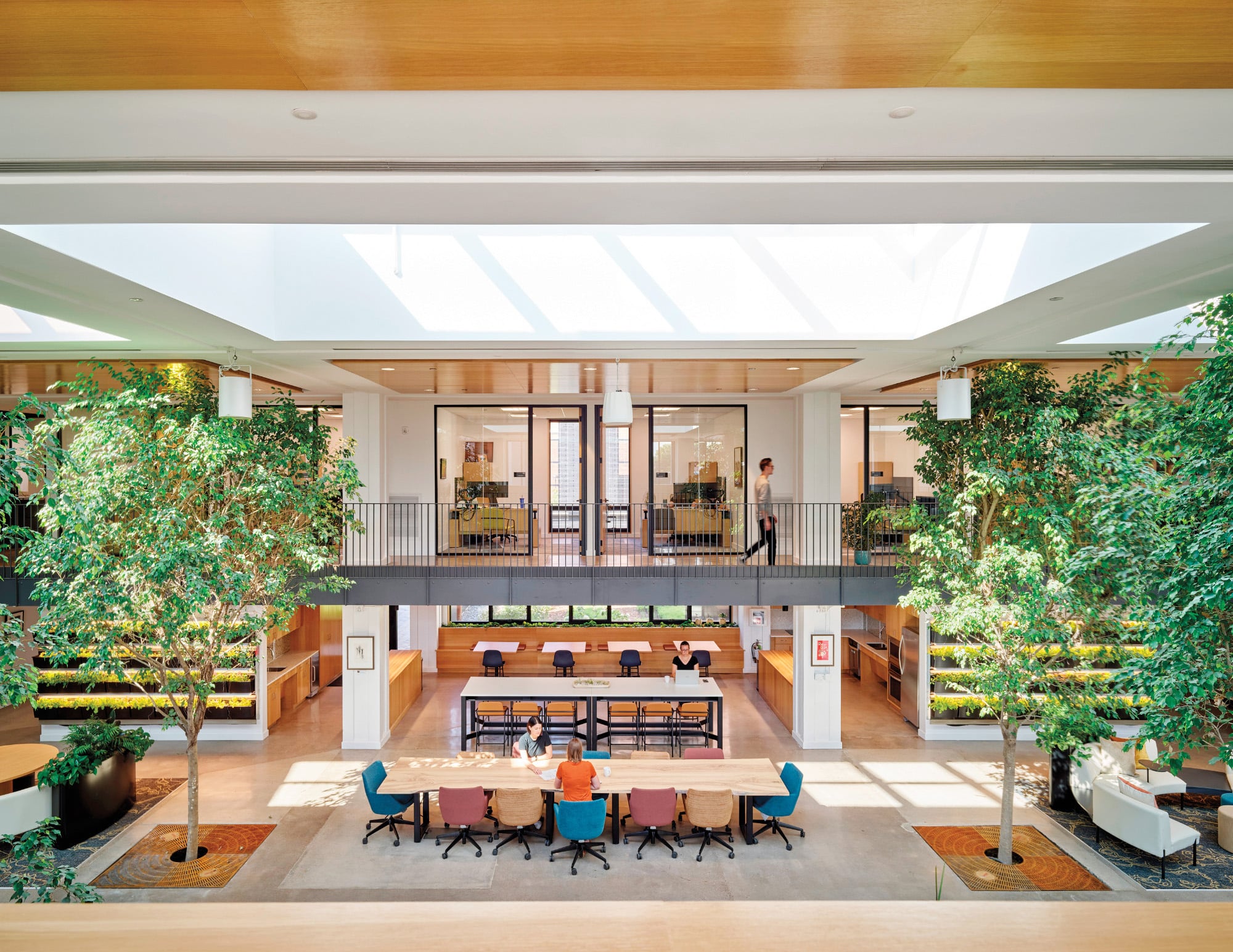 Interior of the Stanley Center for Peace and Security in Iowa, a Living Building Challenge project featuring large indoor trees, abundant skylights, and natural wooden workspaces
