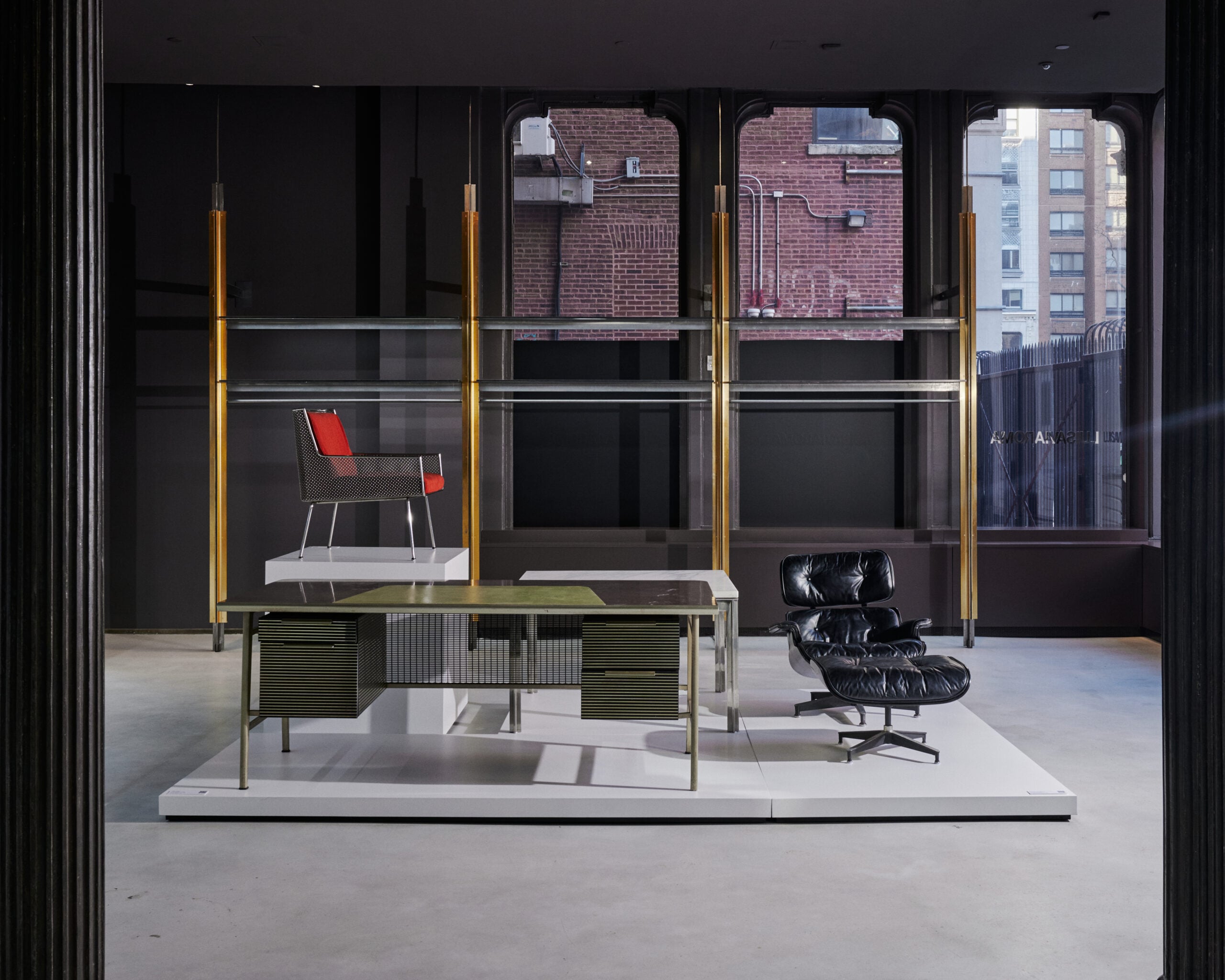 Chairs sit on a gray plinth in a monochrome interior