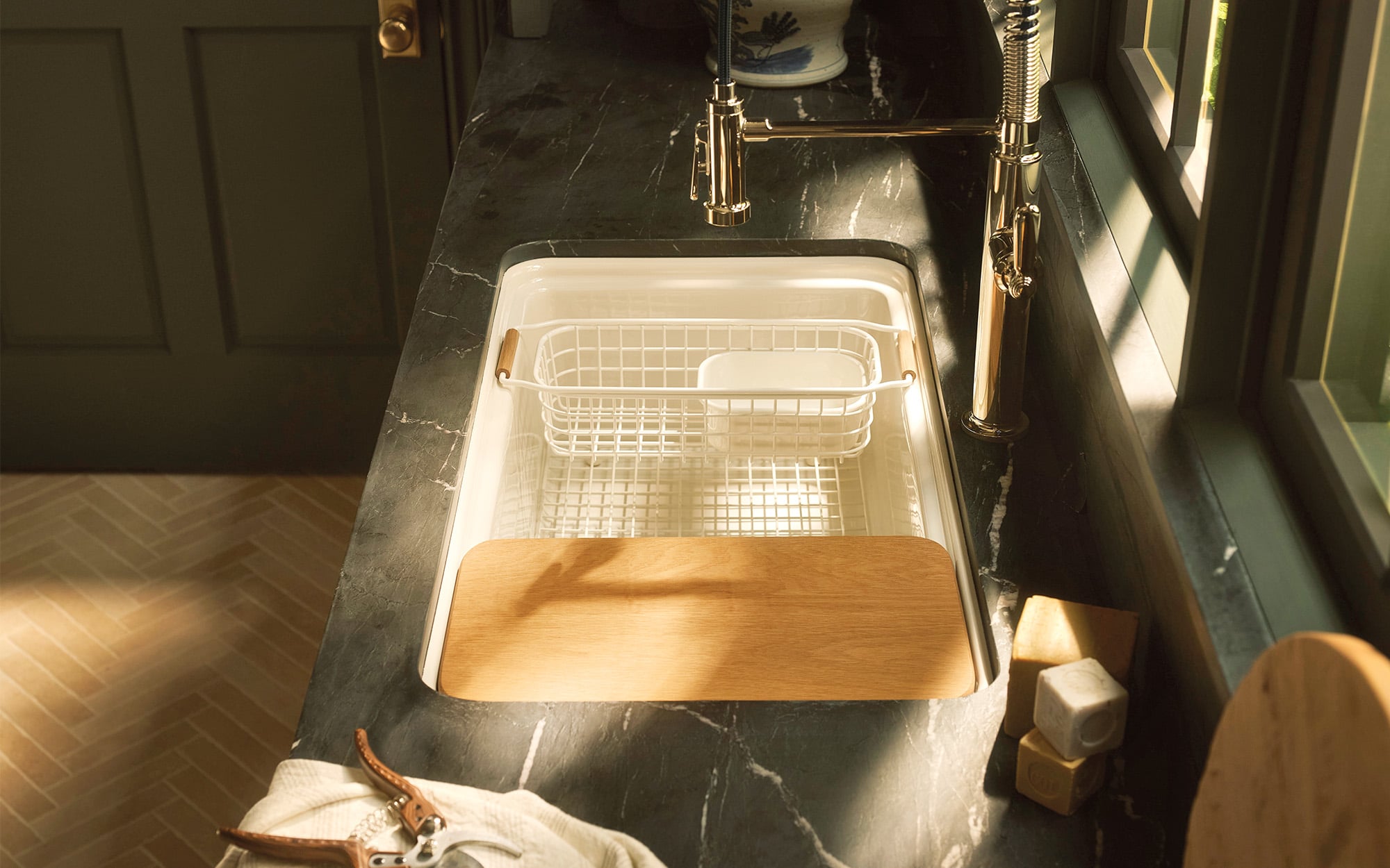Audrine countertop by Kohler in a farmhouse-style kitchen, with dish rack in sink and tiled flooring