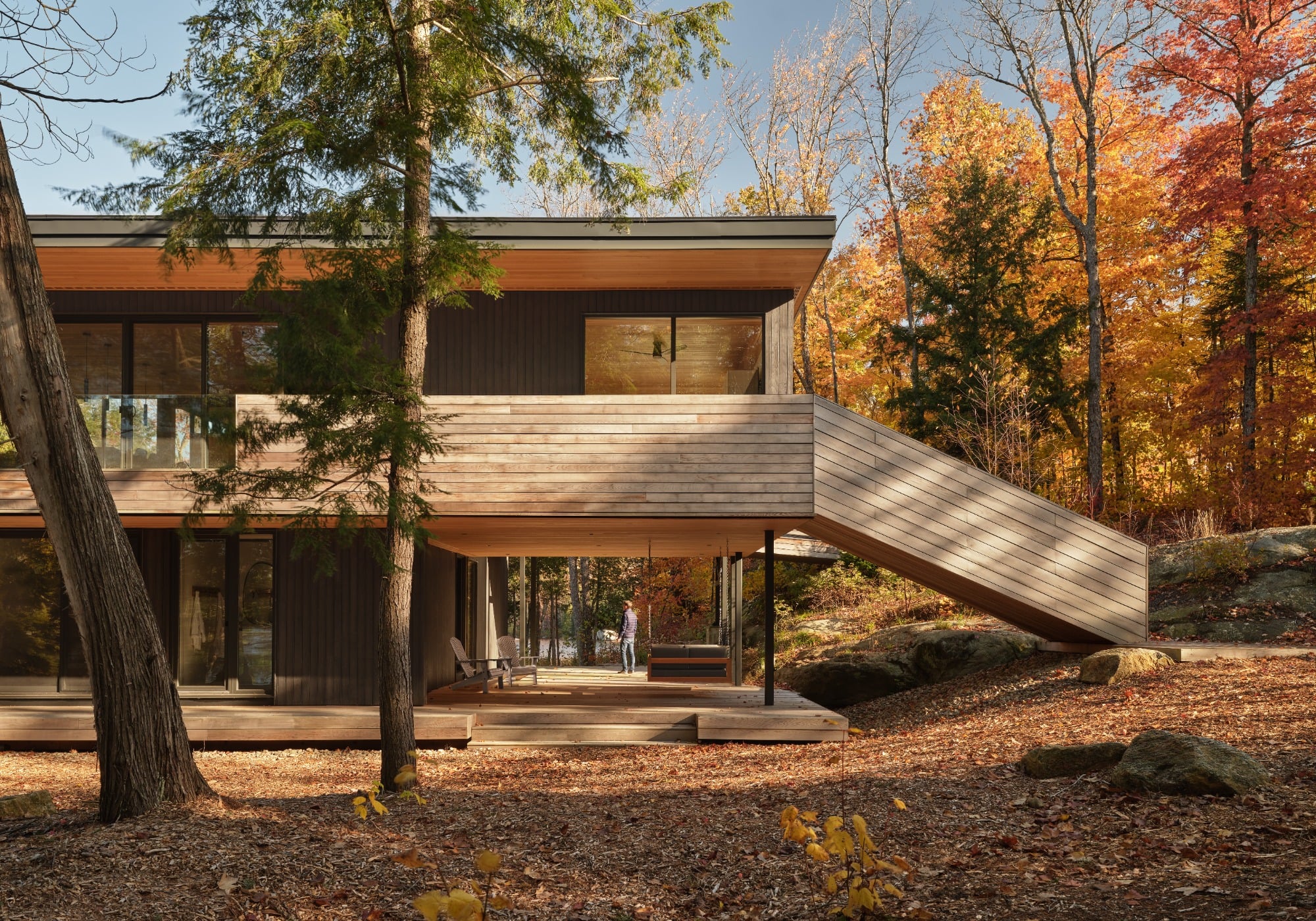 Two-storey Muskoka cottage in autumn trees.