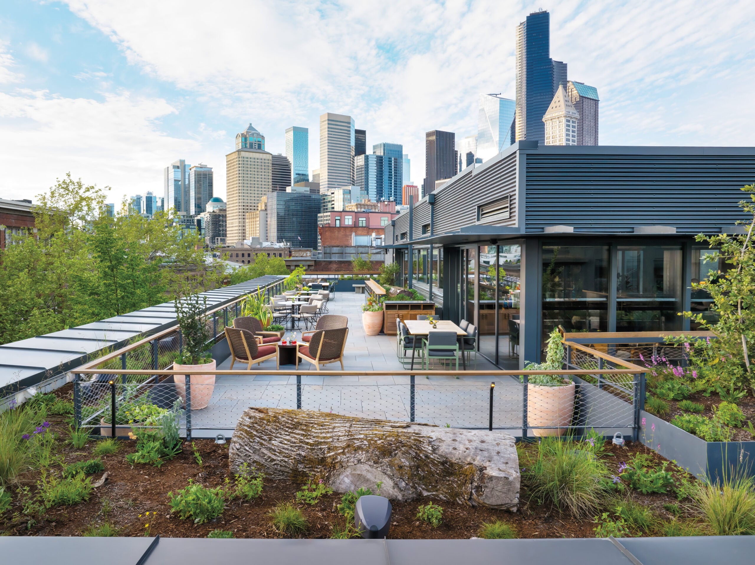 Top-floor bar and seating area with a garden overlooking downtown Seattle, Elliott Bay, and the Olympic Mountains.