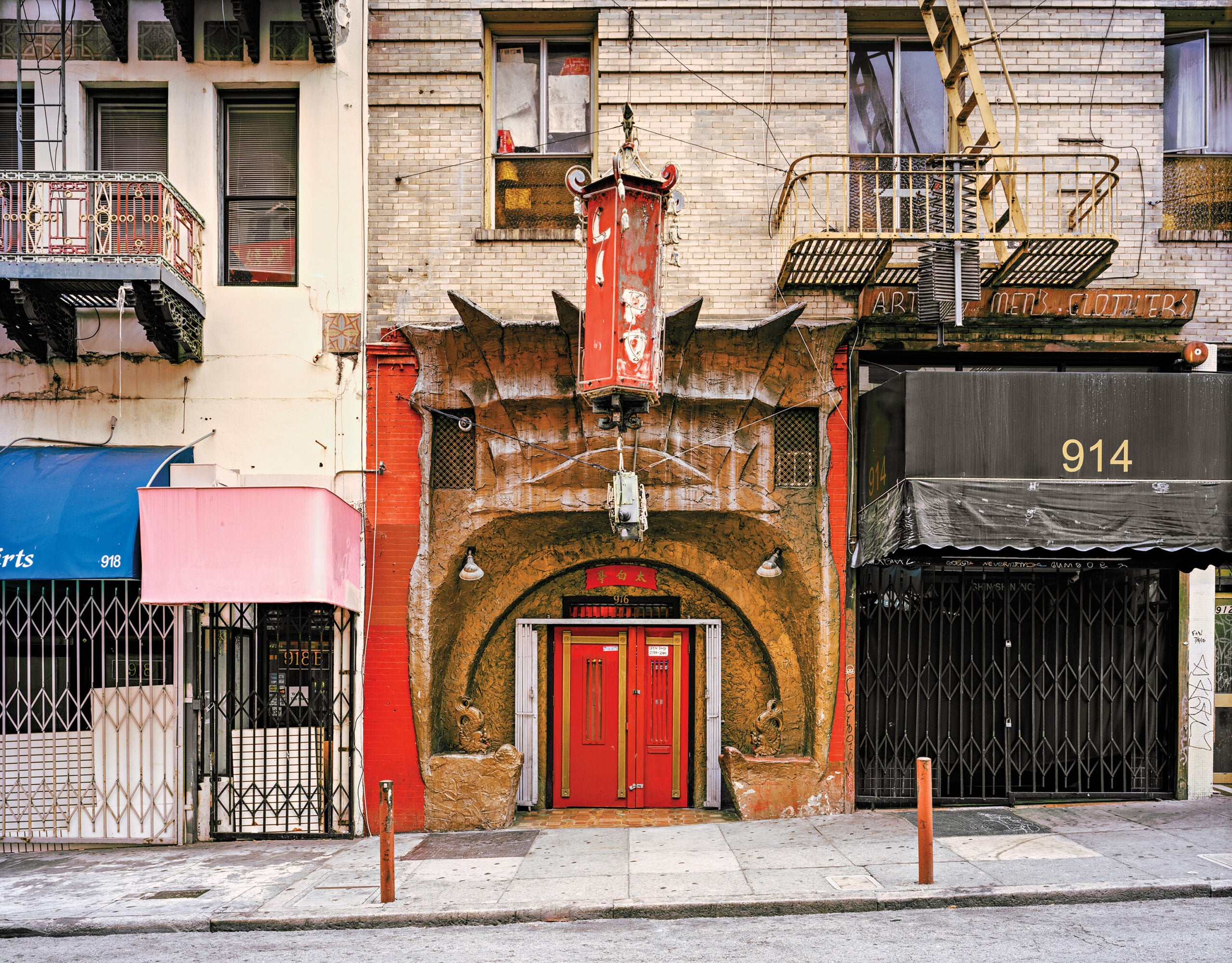 Morris Lum. Chinatown streetview with bold, brown facade.