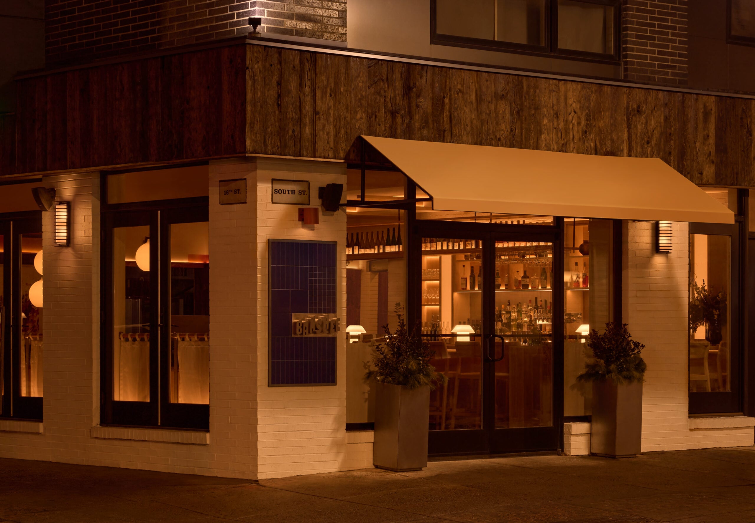 On South Street, Banshee Restaurant features white brick, wide glass windows, and warmly-lit interiors