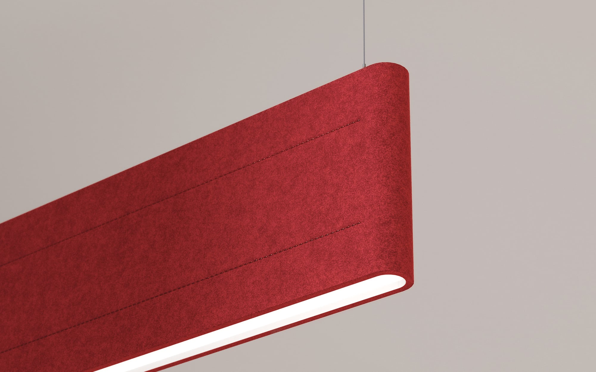 A close-up of a modern, rectangular red pendant light fixture suspended from the ceiling against a plain beige background.