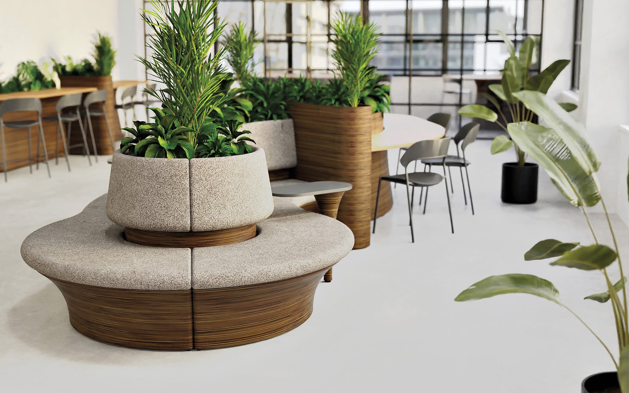 Modern office space featuring circular seating with material-rich finishes around a built-in planter, additional tables and chairs, and large windows providing ample natural light.