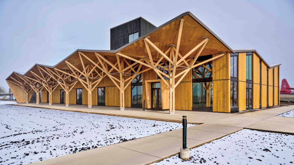 Wood museum building by Leers Weinzapfel Associates in snowy landscape with timber beams and angular roof.