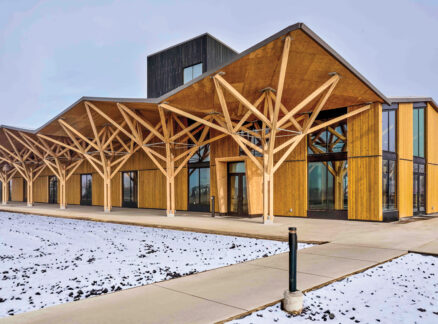 Wood museum building by Leers Weinzapfel Associates in snowy landscape with timber beams and angular roof.