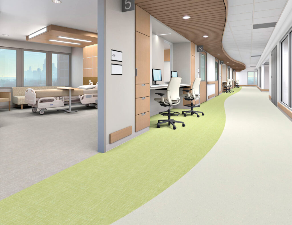 Modern hospital interior with patient beds on one side and a curved hallway with workstations and chairs on the other, featuring light colors and large windows.