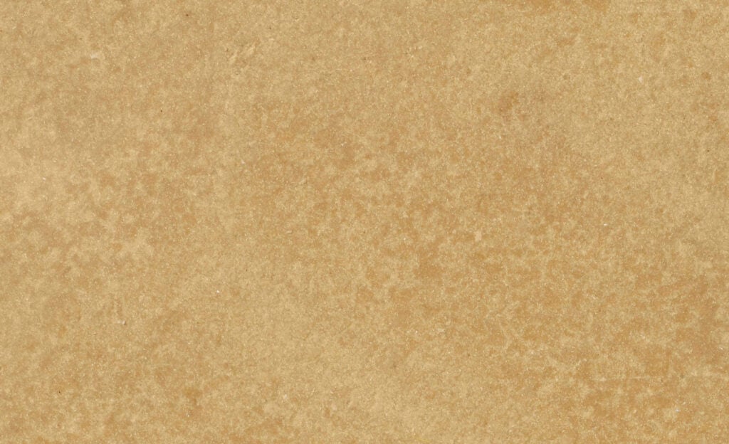 A close-up view of a light brown, textured surface resembling stone or concrete that is made of biobased materials: flaxwood.