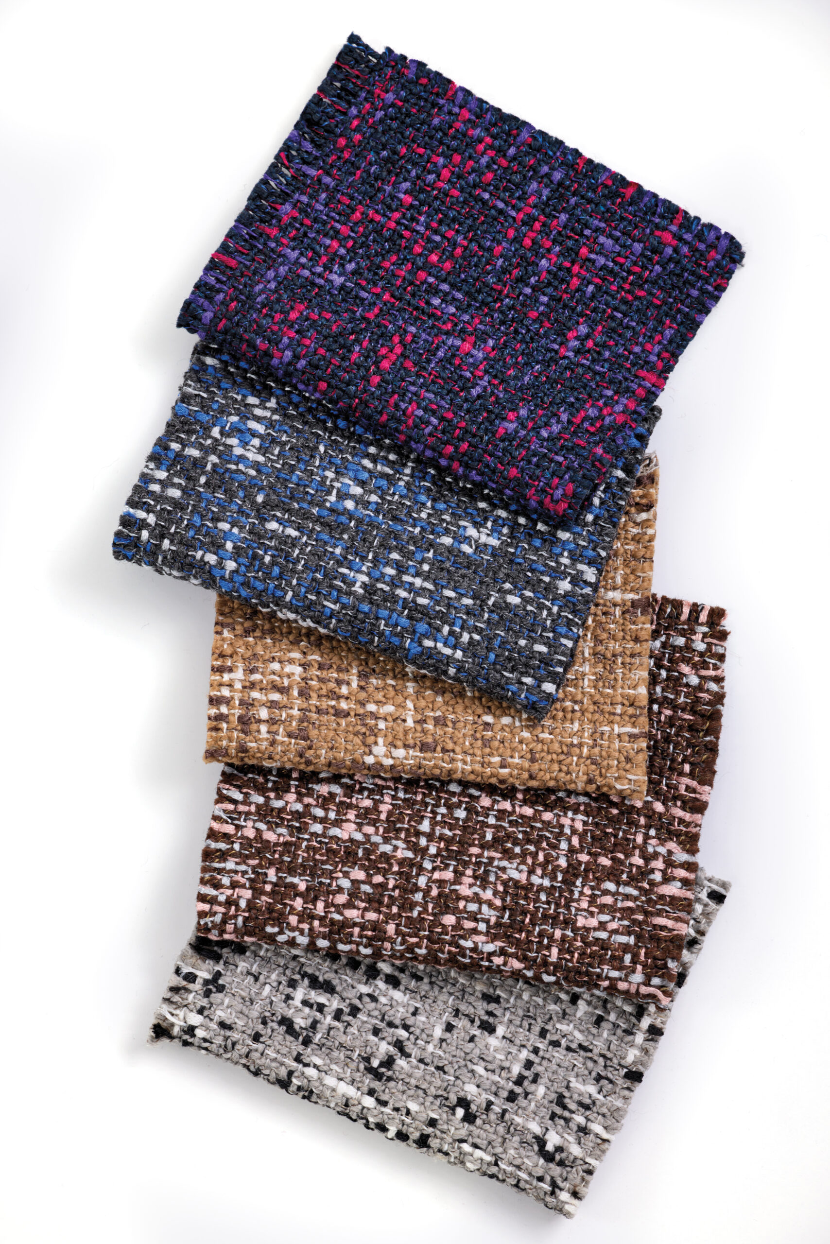 Five rectangular fabric swatches with a textured, woven pattern in various colors—navy with pink, blue, gray, brown, and beige—arranged in a staggered stack on a white background.