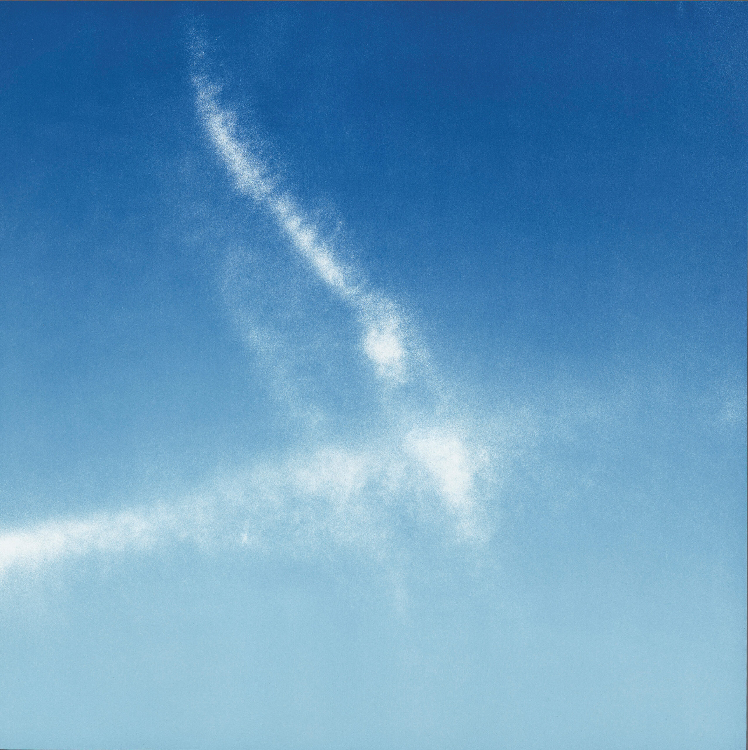 Wispy white clouds form streaks against a clear blue sky.