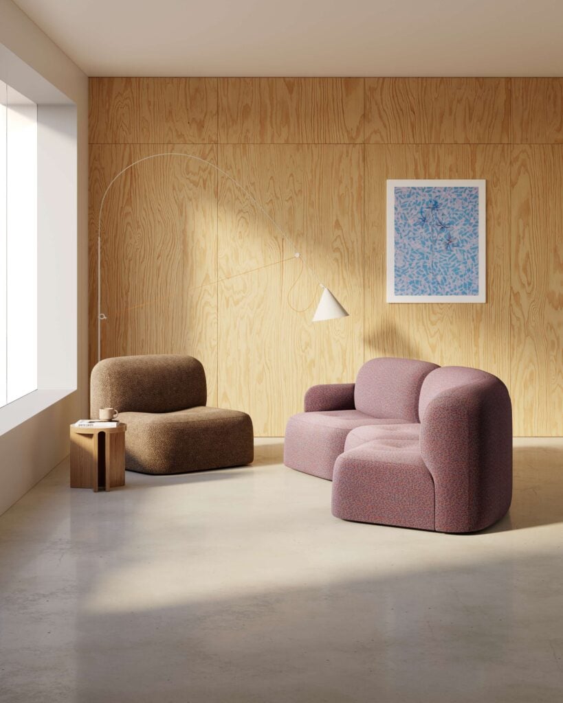 Minimalist living room with light wood panel walls, a large window, two modern fabric chairs, a small wooden side table perfect for office products, wall art, and an arched floor lamp with a white shade.