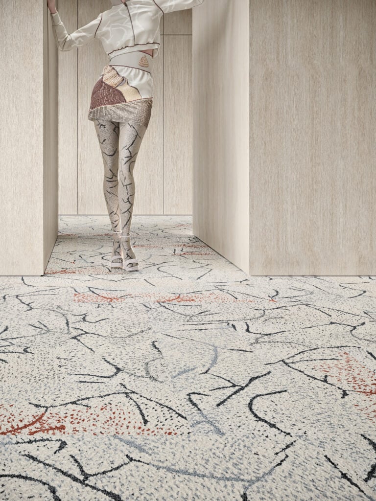 Woman in patterned tights and white outfit stands near wood-paneled walls with a patterned carpet, showcasing her METROPOLISLikes style.