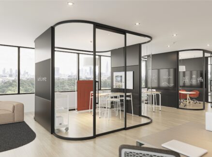 Modern office space with glass-walled meeting rooms, sleek furniture, open seating areas, large windows, and city views in the background.