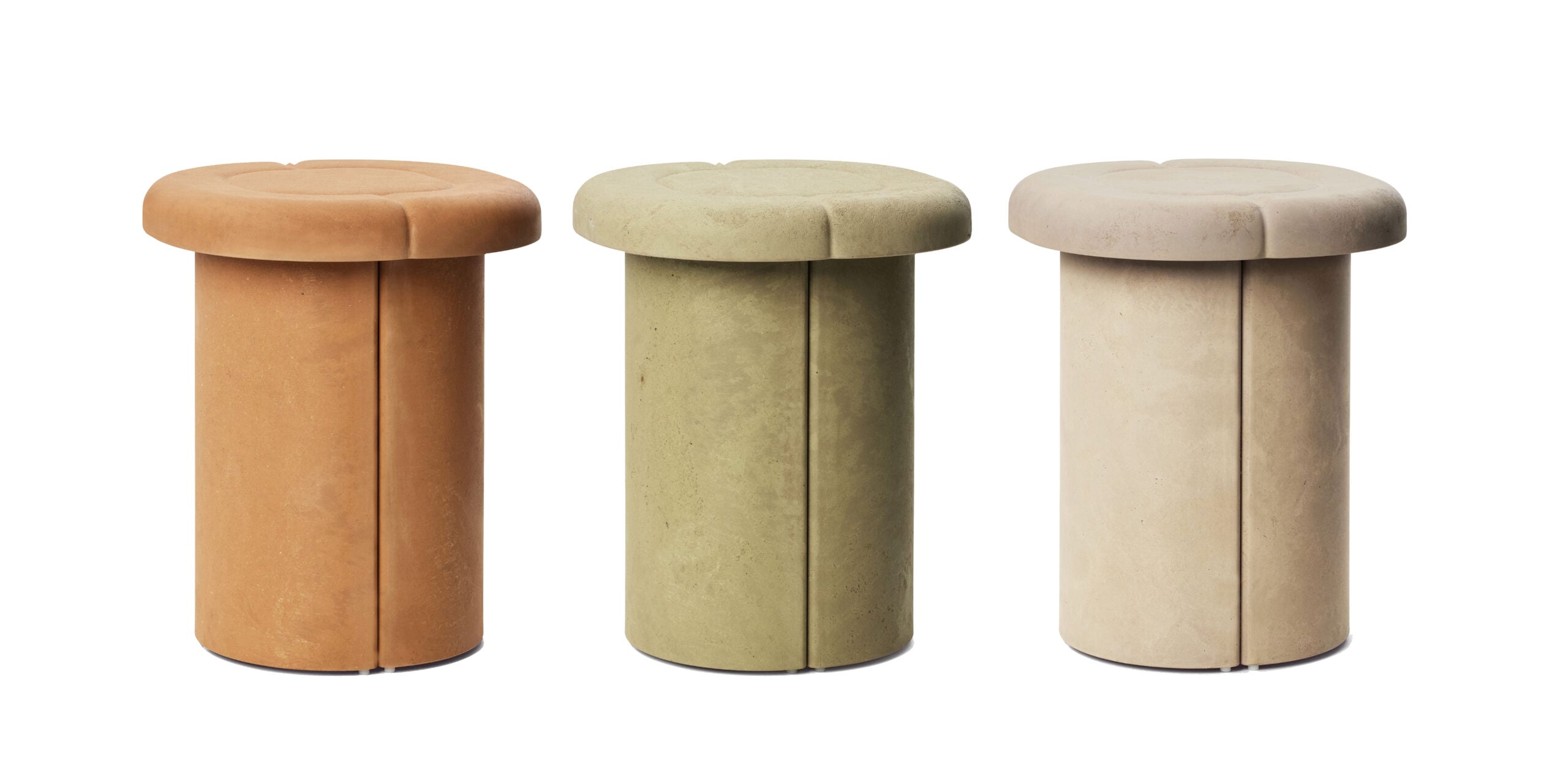 Three cylindrical stools with rounded tops in terracotta, olive green, and beige colors are arranged side by side against a white background.