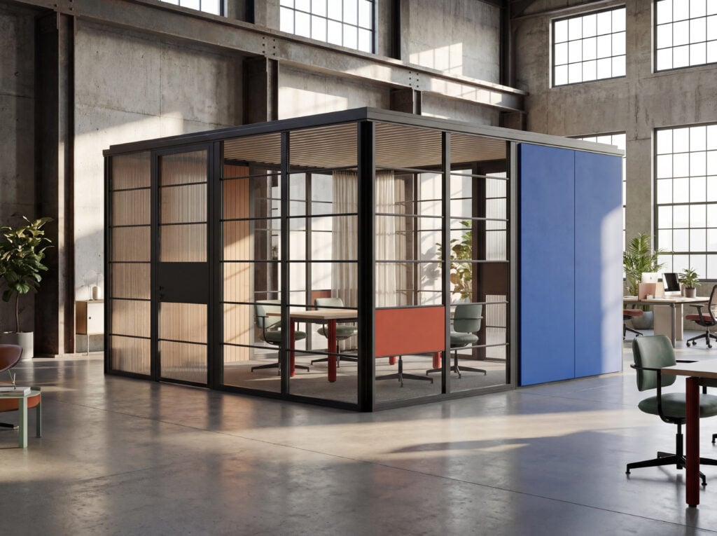 Glass-enclosed meeting room with blue accent wall inside an industrial-style office featuring large windows, concrete floors, modern furniture, and a curated selection of office products for a functional workspace.
