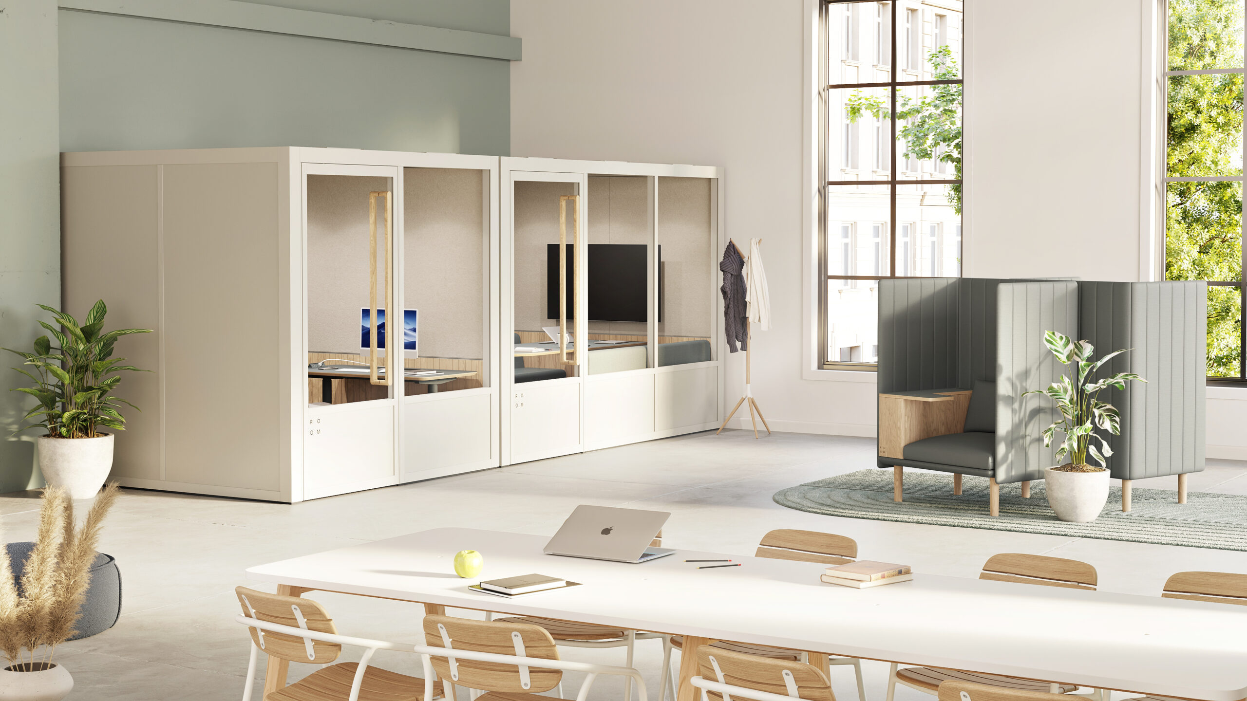Modern, neuroinclusive office space with private work pods, a conference table with chairs, plants, and a seating area near large windows.